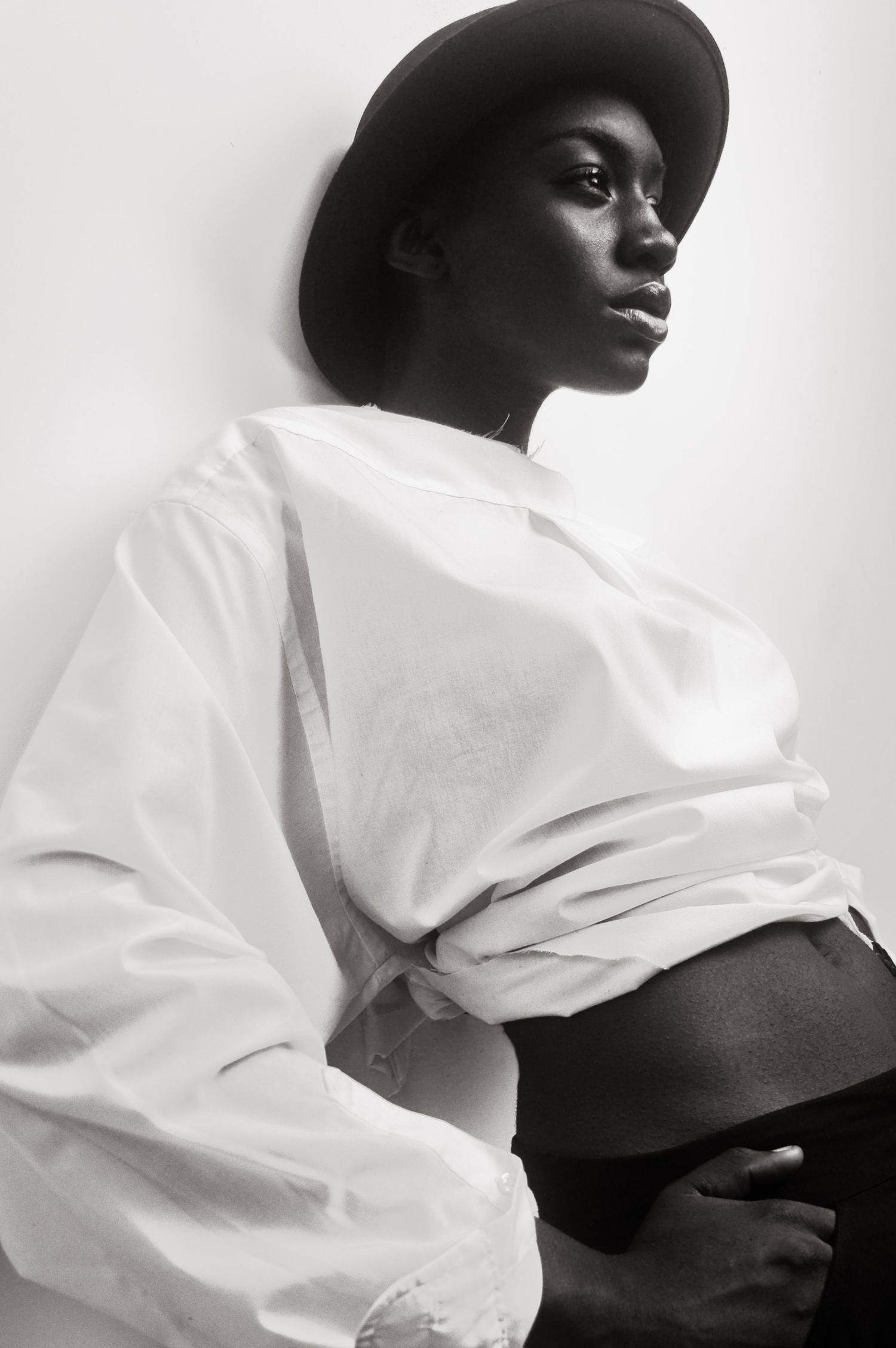 Black and white fashion portraits featuring a wide-brimmed hat and white clothing.