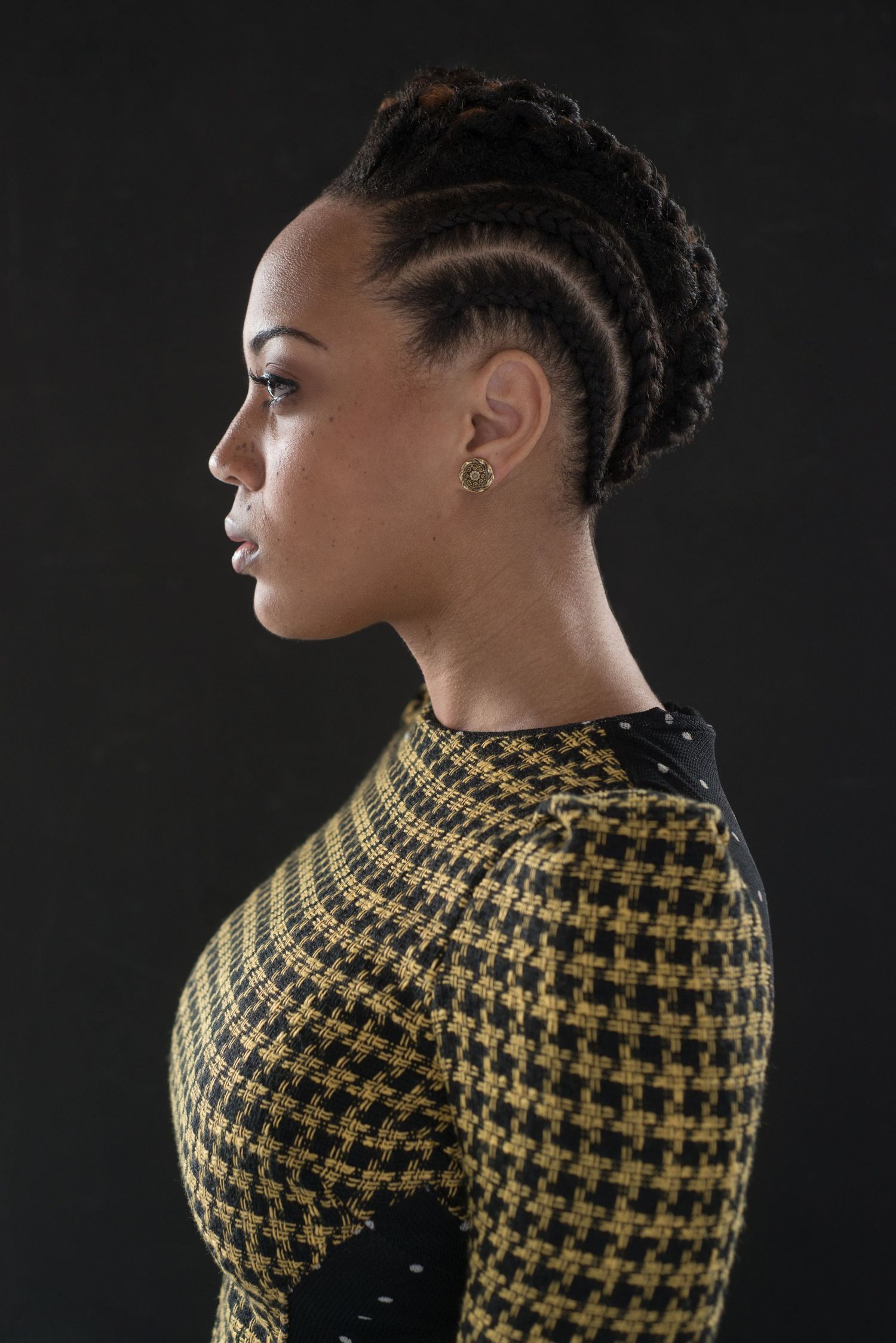 Profile views of a houndstooth pattern sweater or top against a dark background.