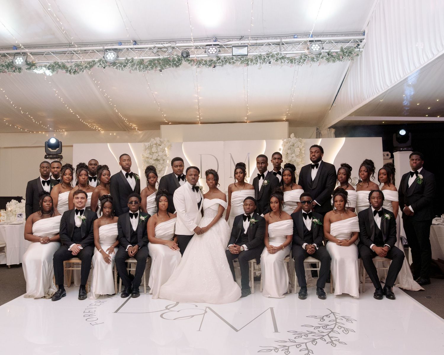 bridal team and couple at reception dance floor group picture