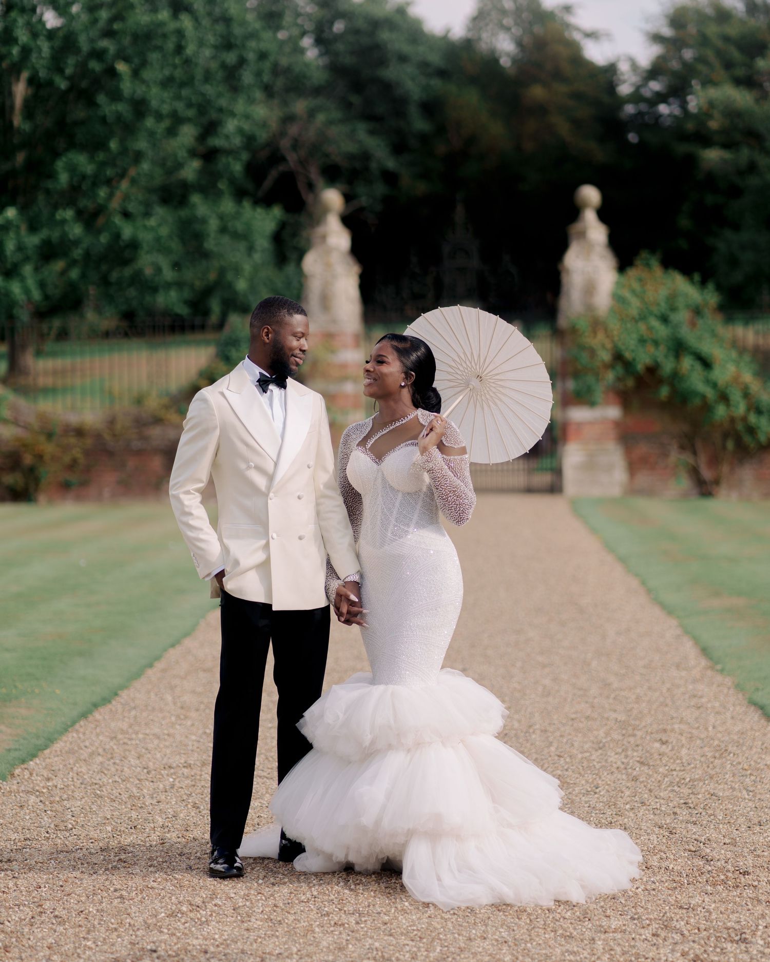 Luxury Romantic wedding portrait of bride and groom looking at each other with love and smiles at the beautiful gardens of North Mymms Park.