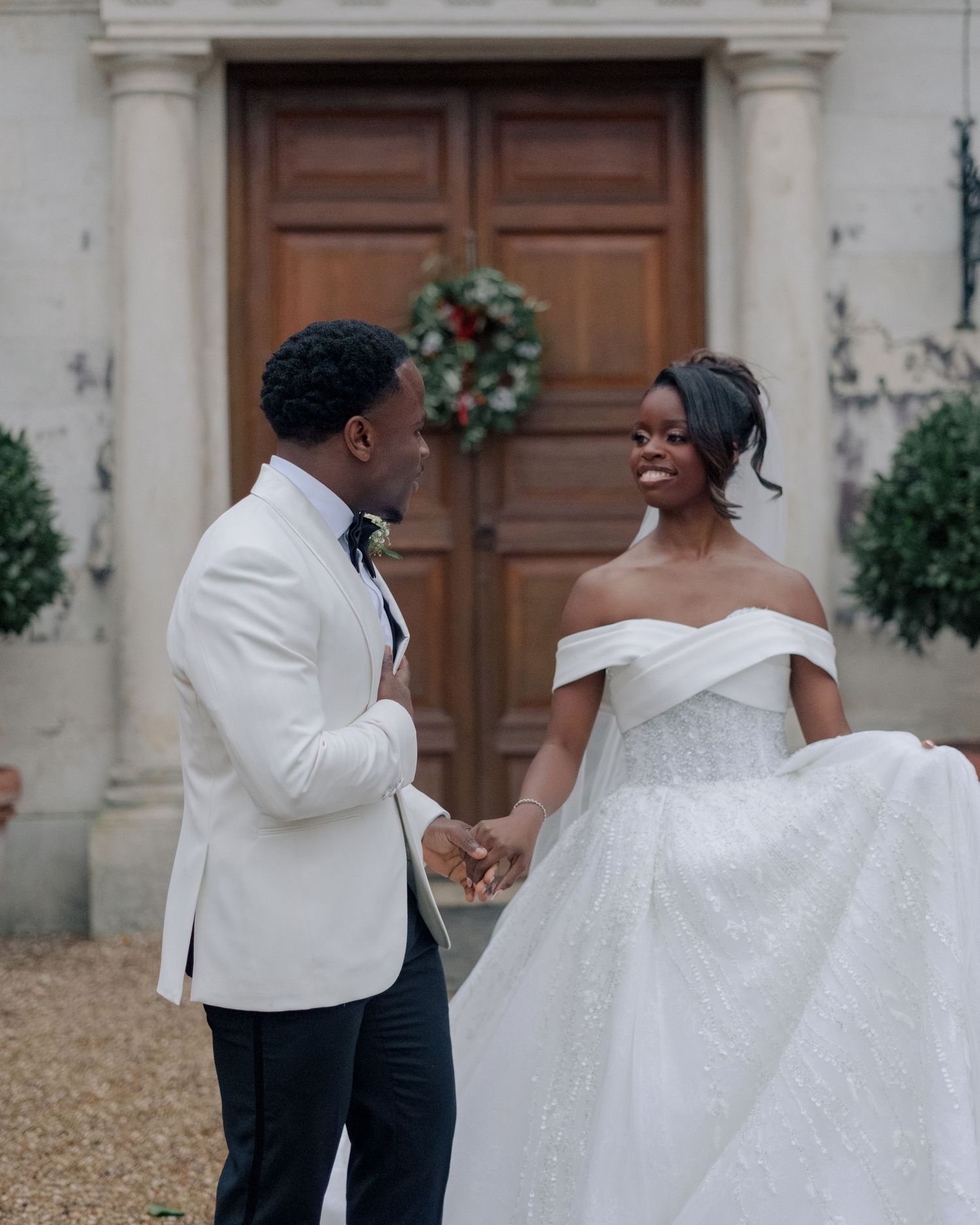 bride and groom walking hand in hand while smiling