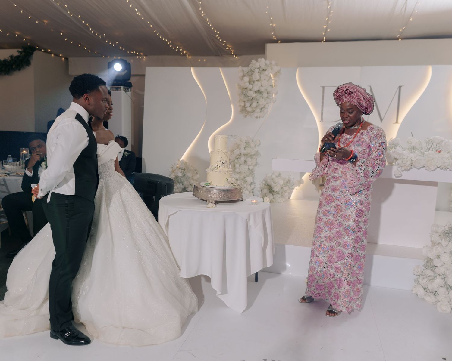 mother making a speech before bride and groom cutting their cake