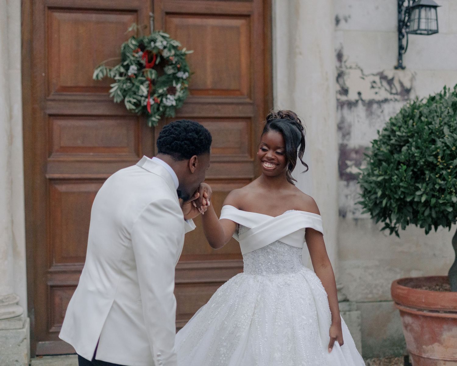 groom kissing the right hand of her bride