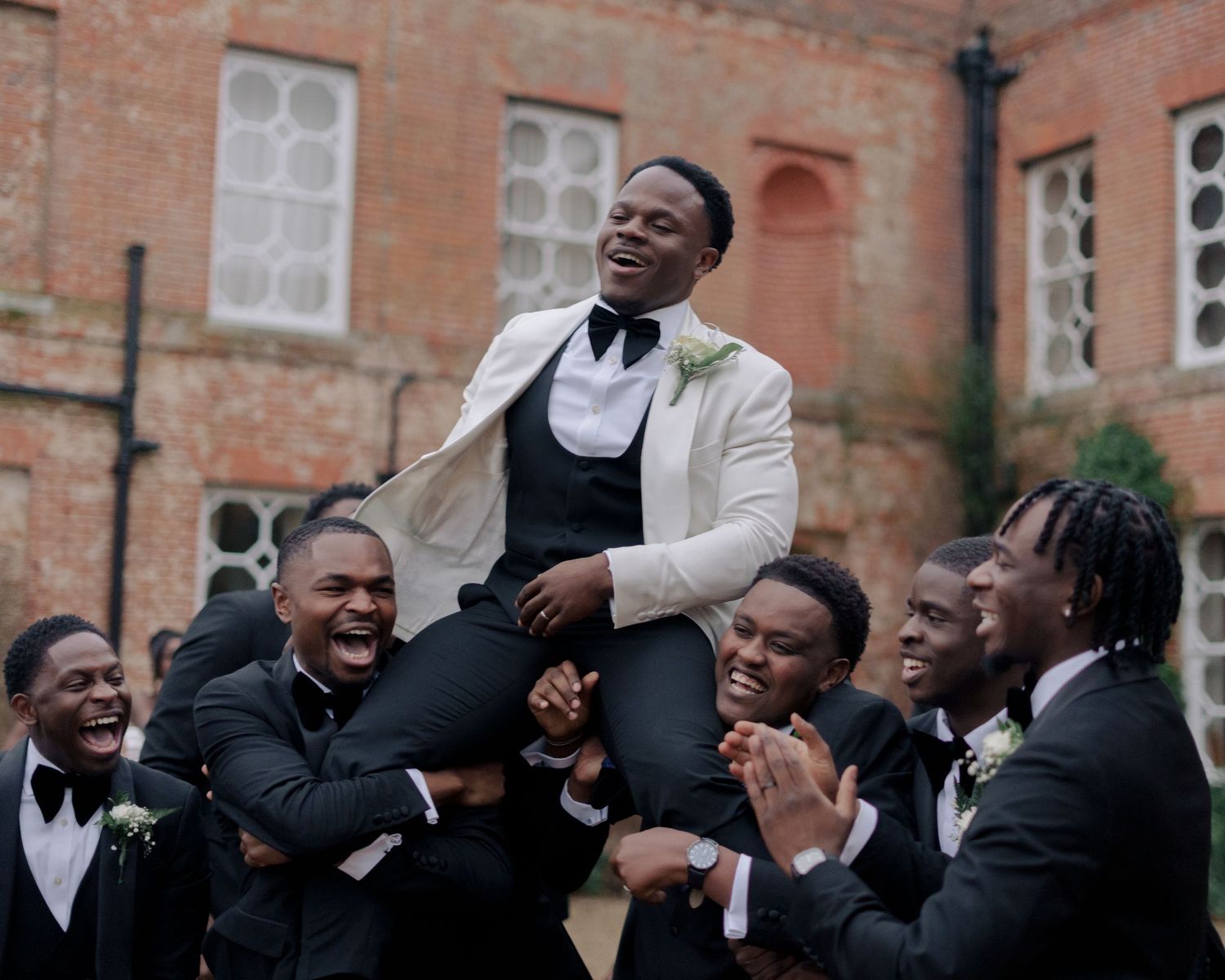 groom picked up by his boys to celebrate him on his wedding day