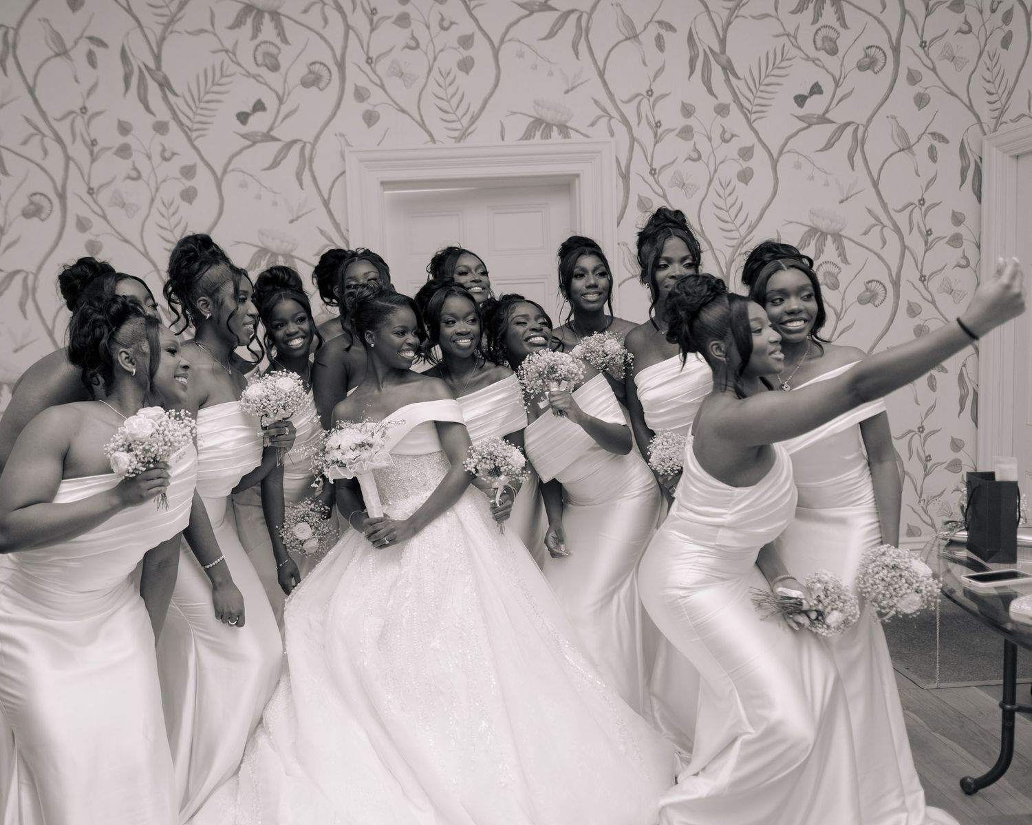 candid black and white image of bride and her girls taking a selfie.