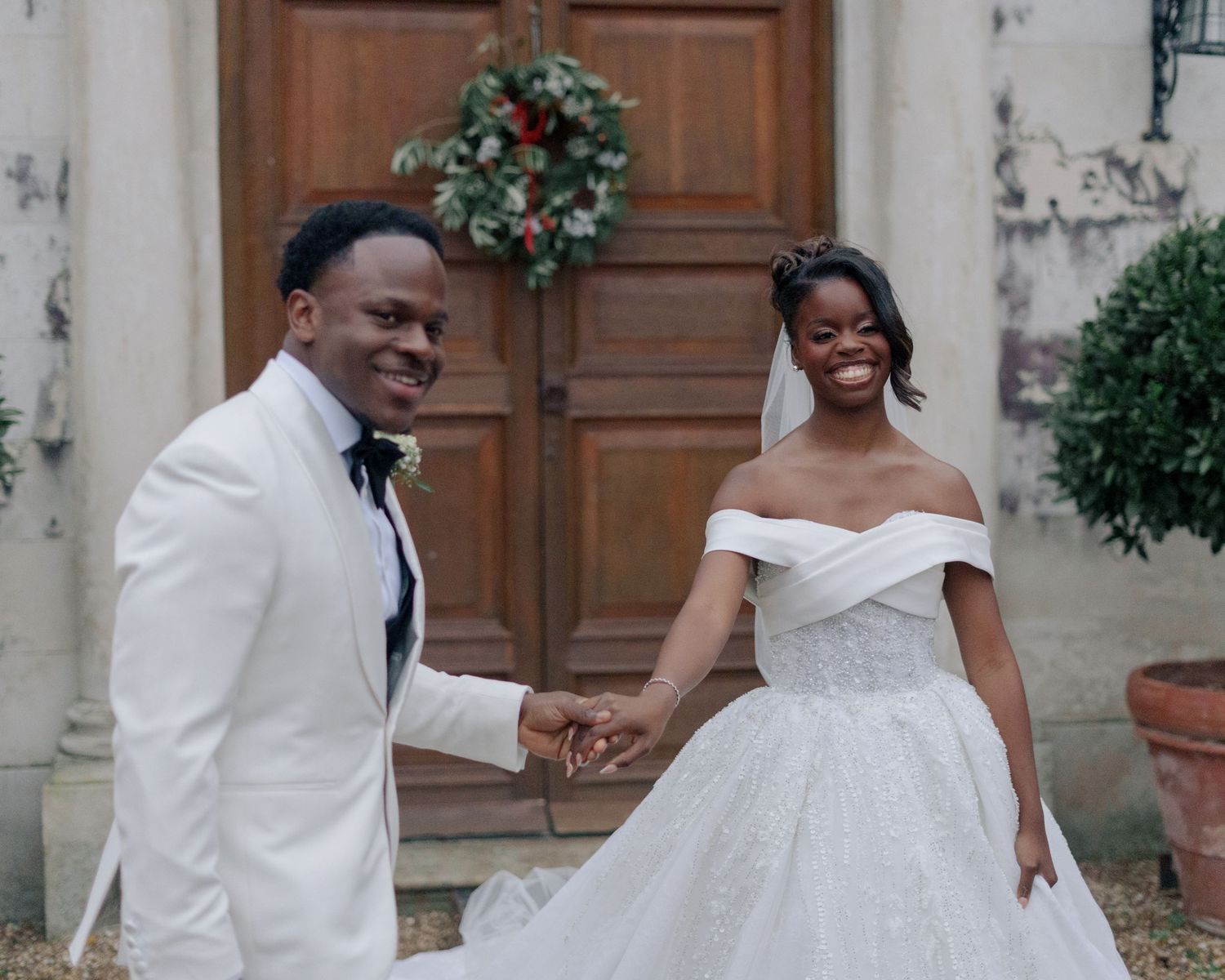 bride and groom walking hand in hand while smiling