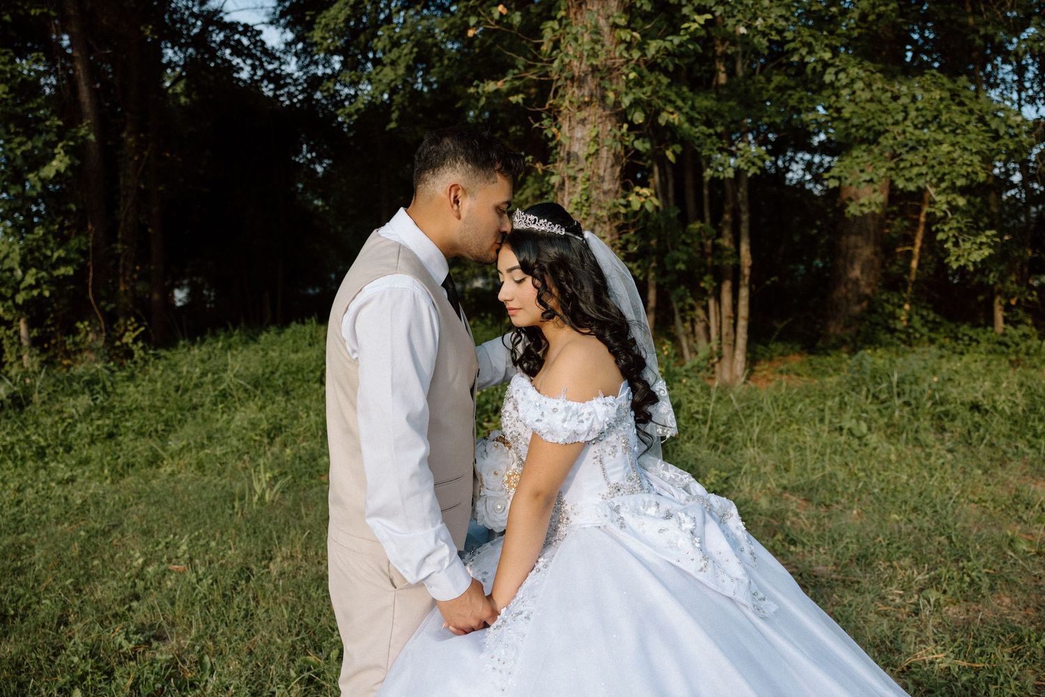A groom kissing his bride on the forehead for their wedding portraits in Richmond Virginia.