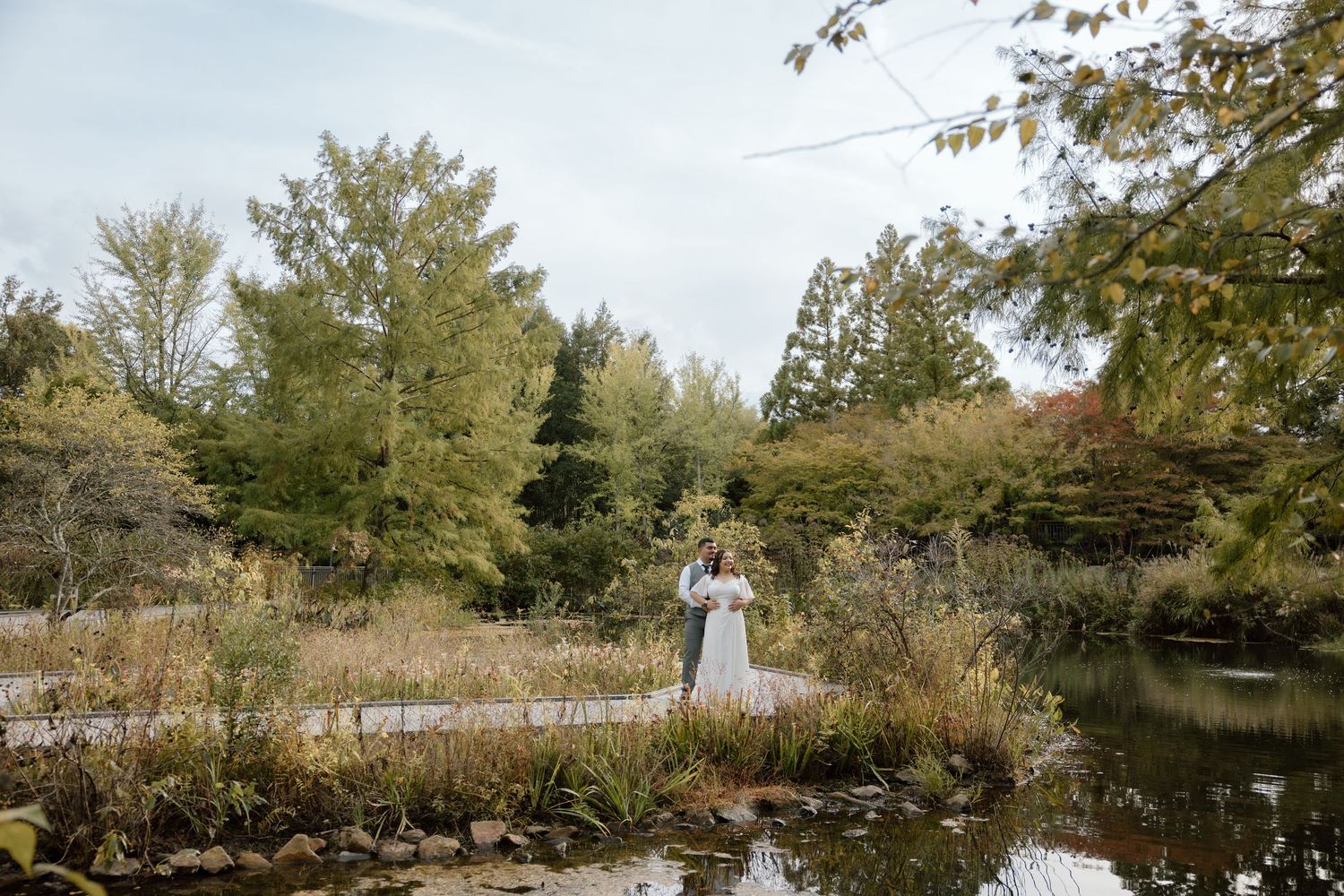 A couple looking over the pond at the Lewis Ginter Botanical Garden for their engagement session.