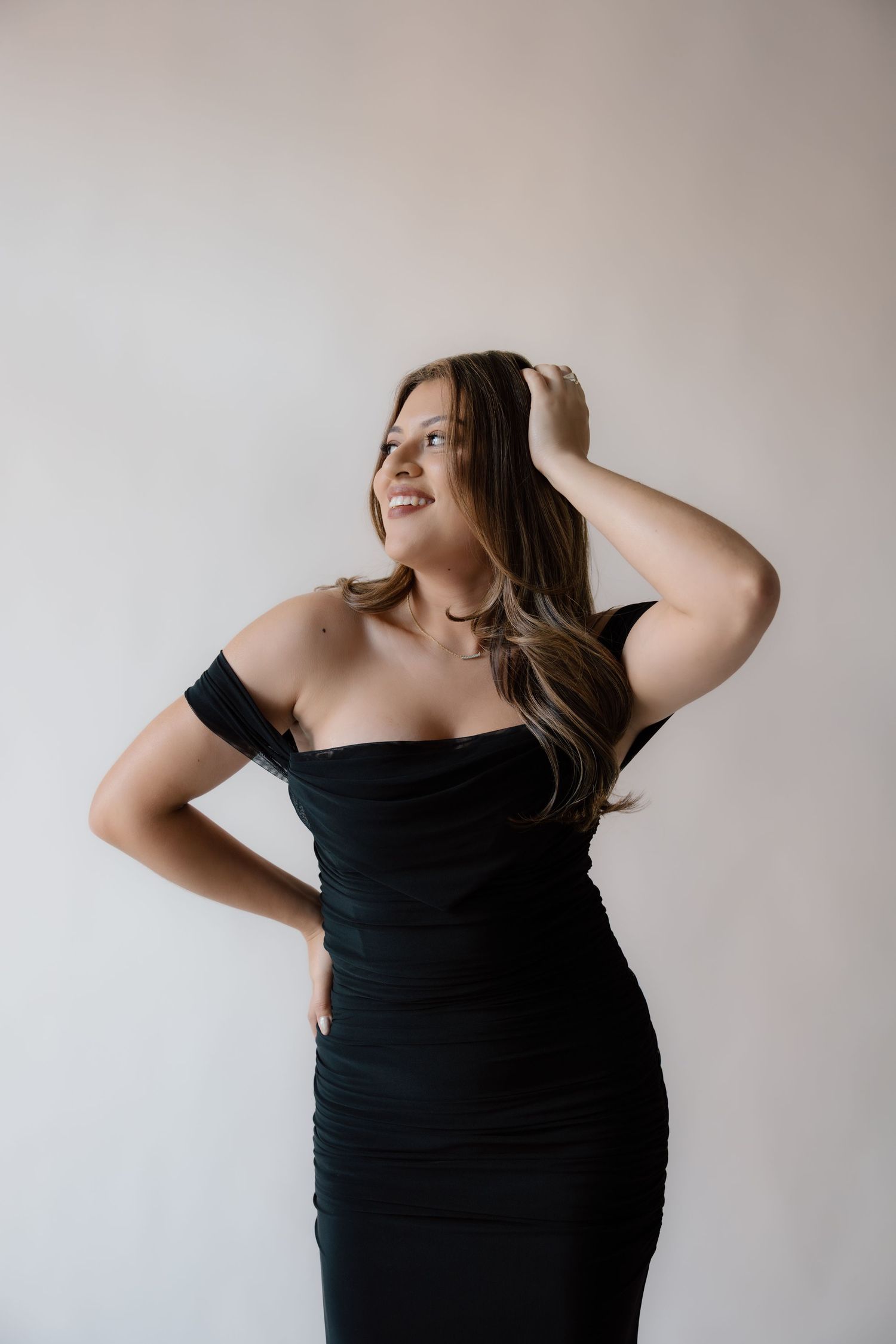A woman in a black dress for her studio birthday session in Richmond Virginia.