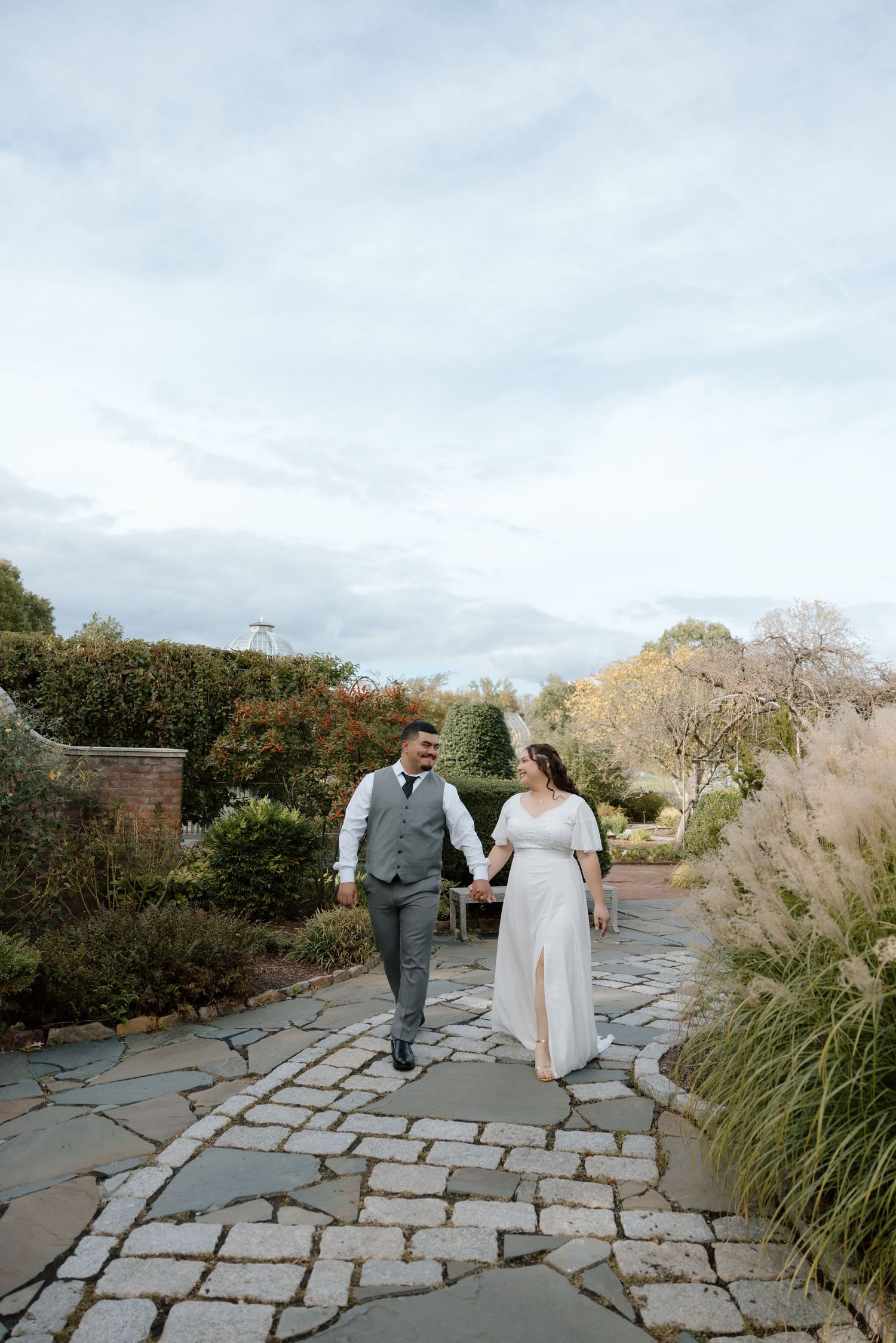 A newly engaged couple walking and laughing at the Lewis Ginter Botanical Garden in Richmond Virginia.