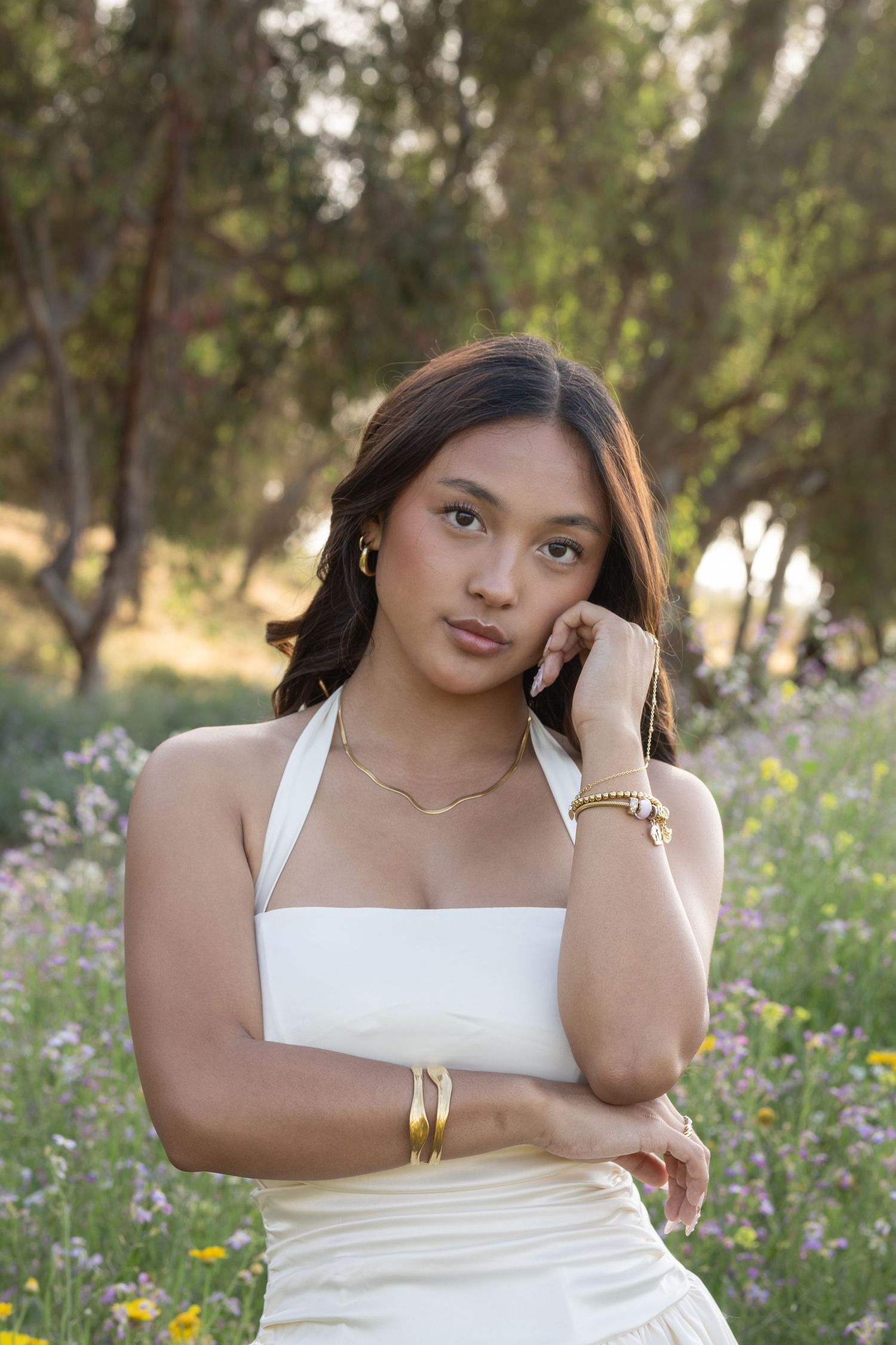 Portrait session in a wildflower field with white top against natural backdrop.