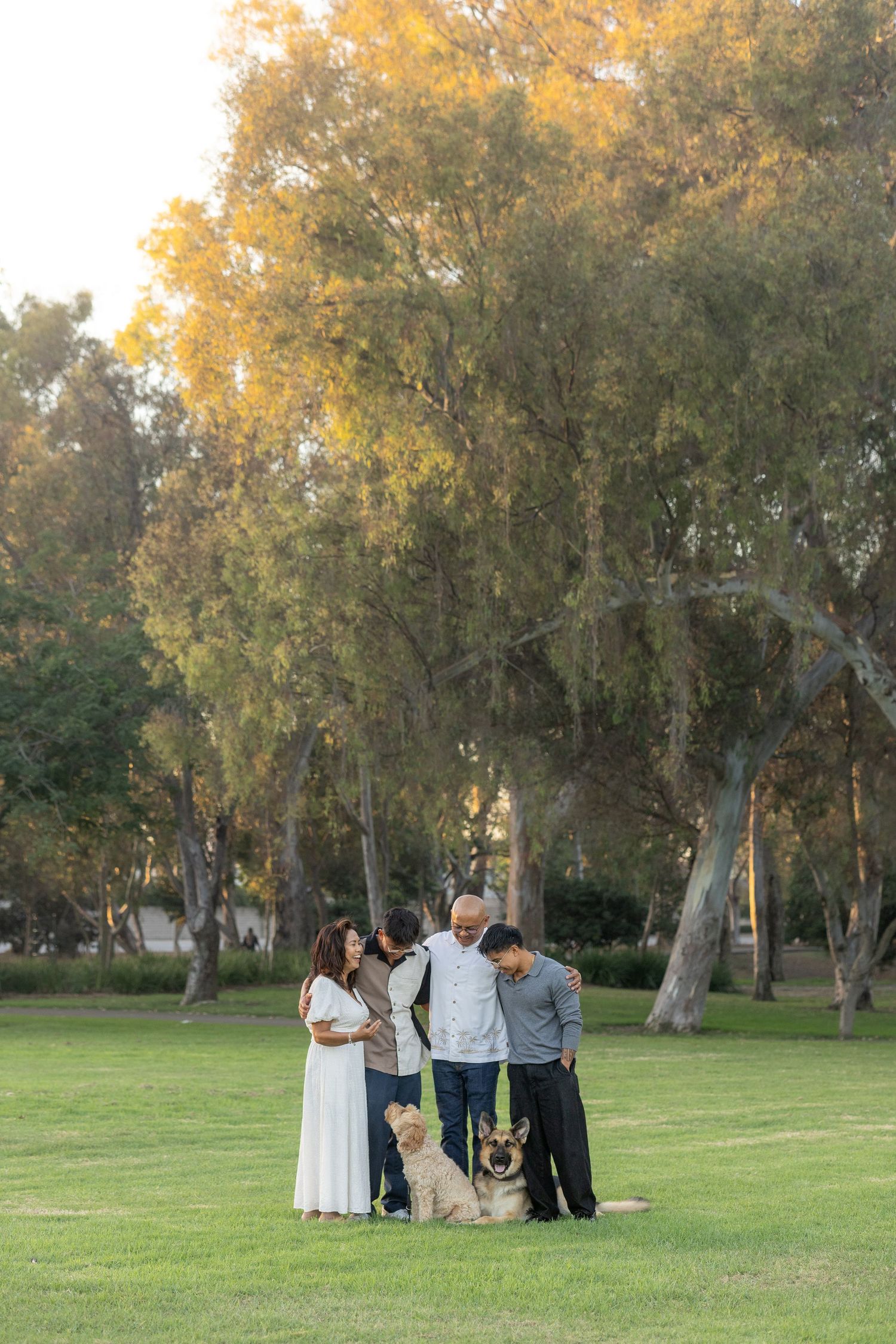 Group enjoying a casual photoshoot in a park with eucalyptus trees.
