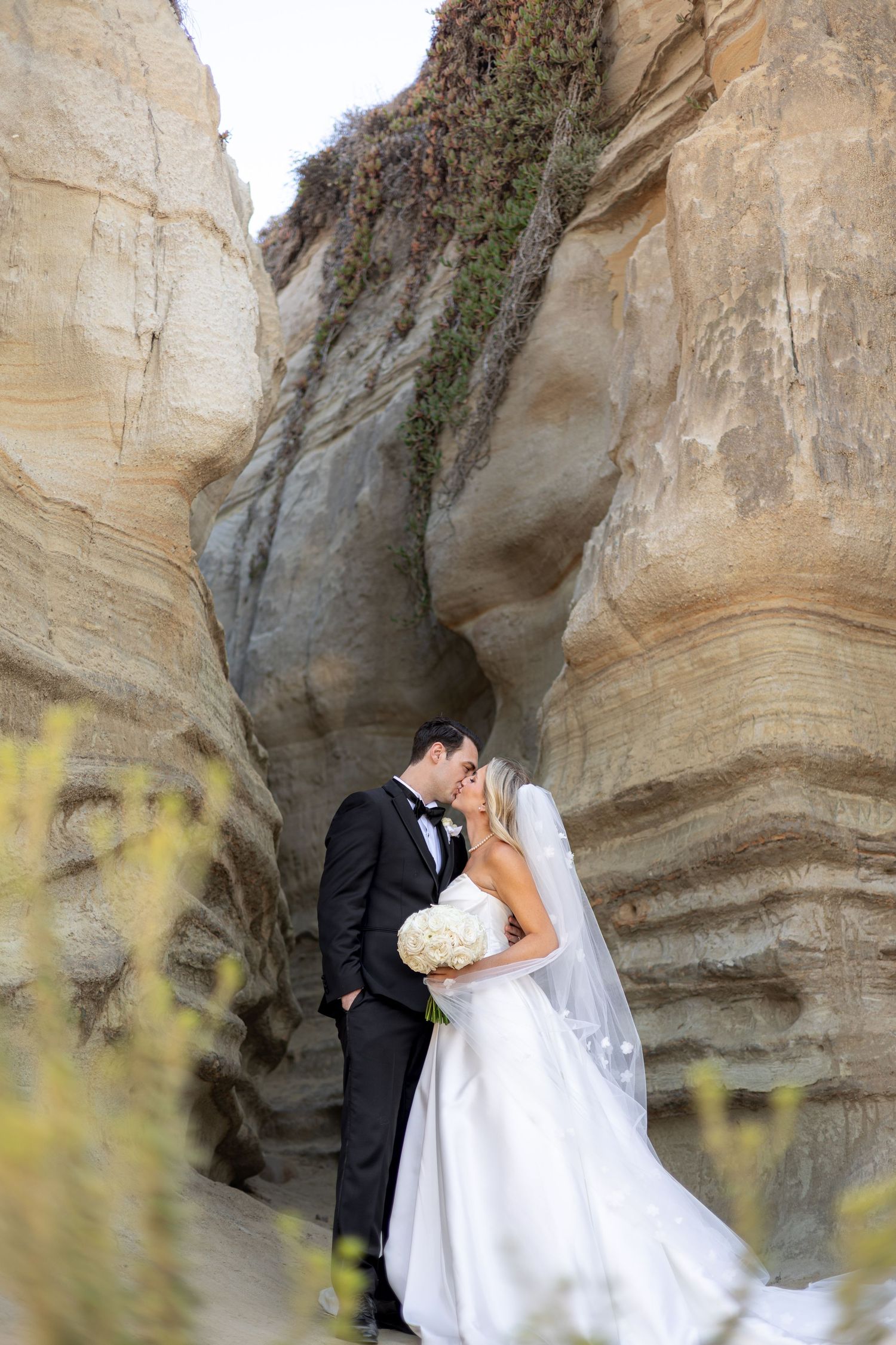 Romantic wedding portraits against textured sandstone cliffs.