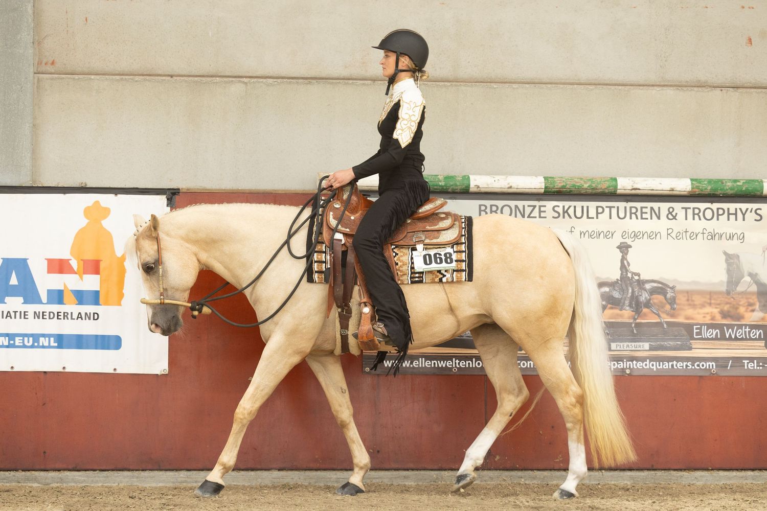 Palomino horse and rider competing in western equestrian event.