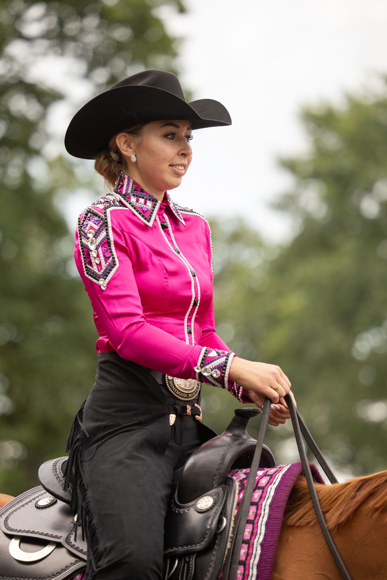 Rider in bright pink jacket practicing equestrian techniques on horseback.