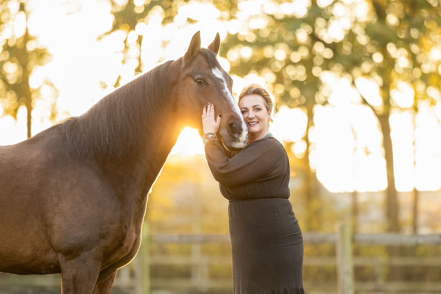 Horse and companion enjoying a tender moment in a field during golden hour sunset.