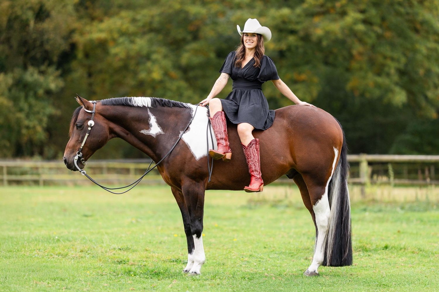 Woman and horse enjoying time together in sunny green pasture.