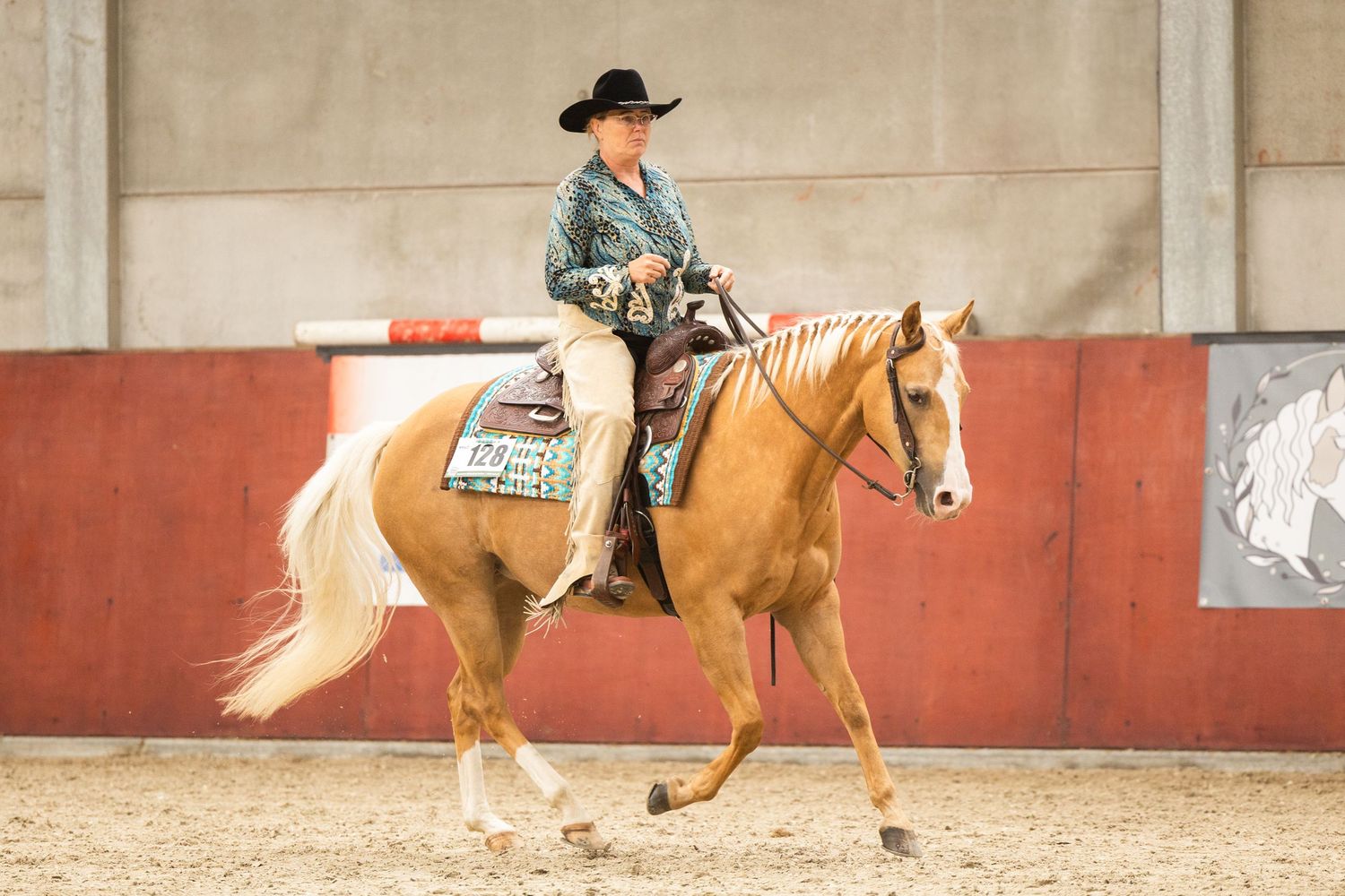 Palomino horse and rider competing in western pleasure class.
