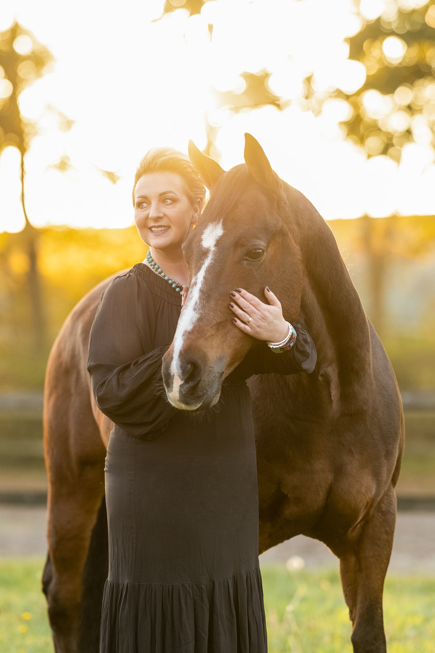 Quarter Horse and person sharing affectionate moment in sunlit field with bokeh background.