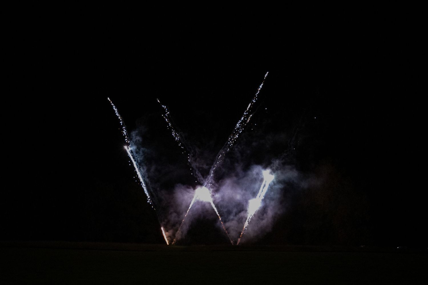 Stunning fireworks display lighting up the night sky at an outdoor wedding celebration.