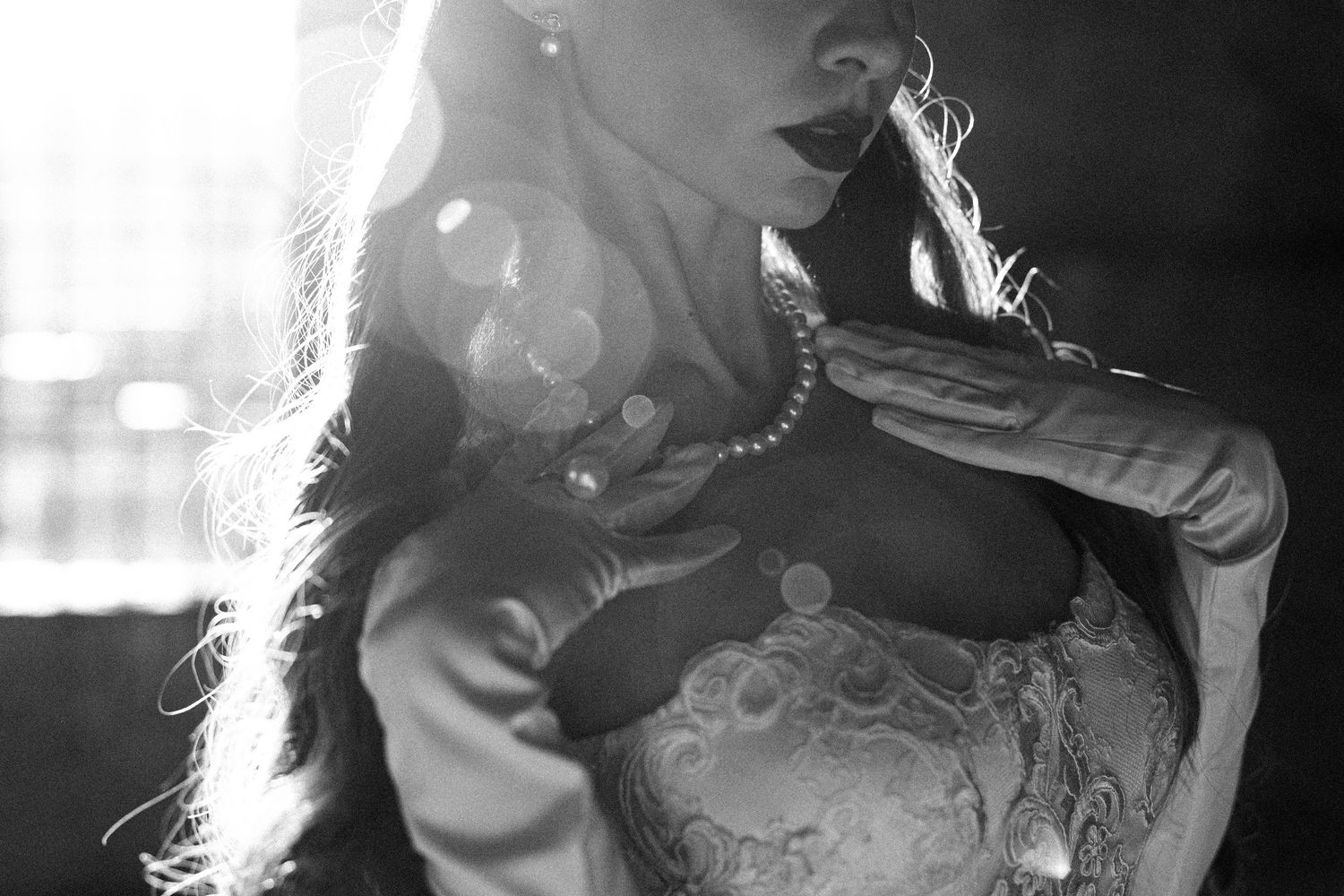 A couple shares an intimate moment in black and white wedding photography with dramatic lighting and shadows.