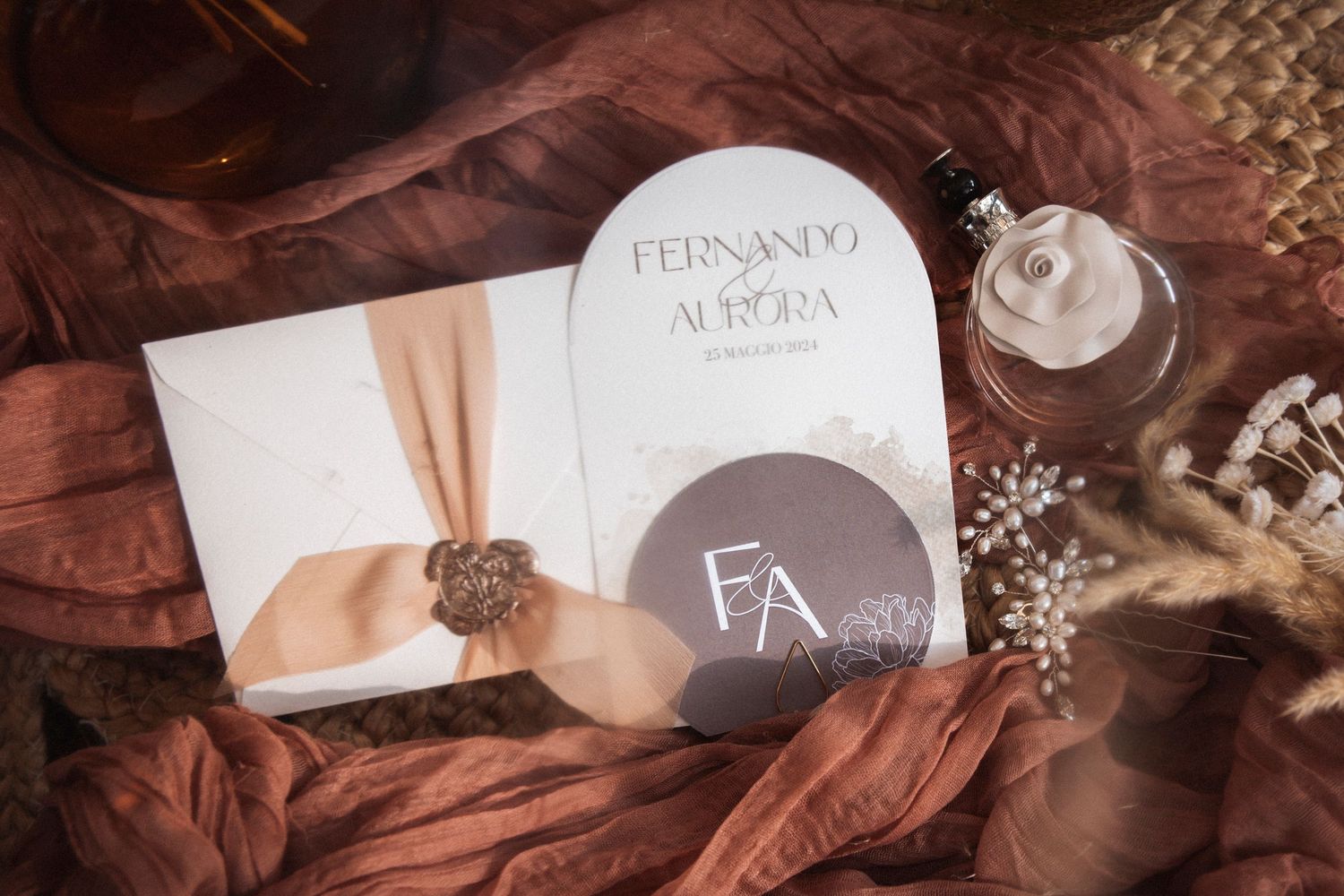 Wedding stationery and invitations arranged artistically on a dark textured surface with soft lighting.