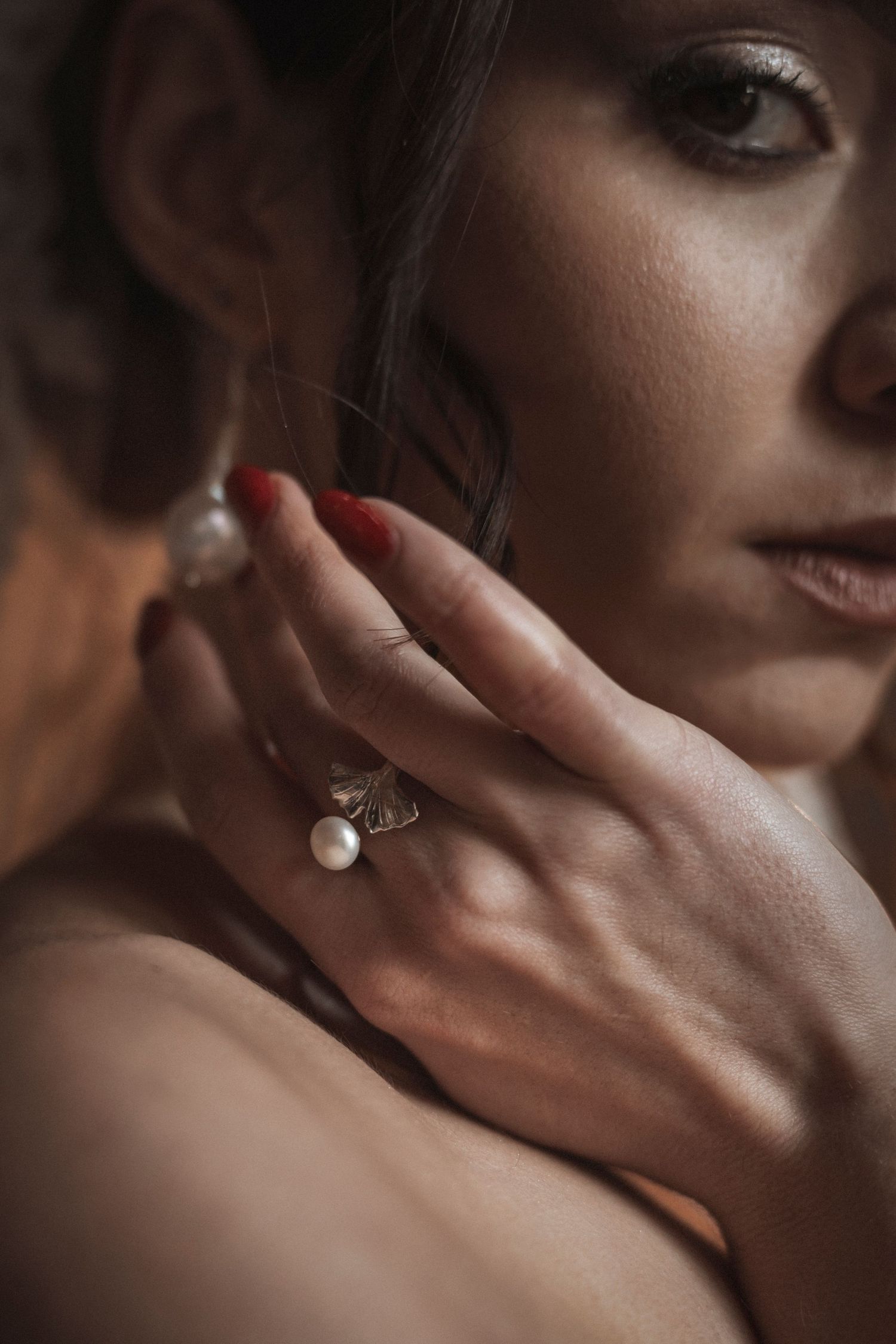 A close-up artistic photo series showing hands with jewelry against a dark background.