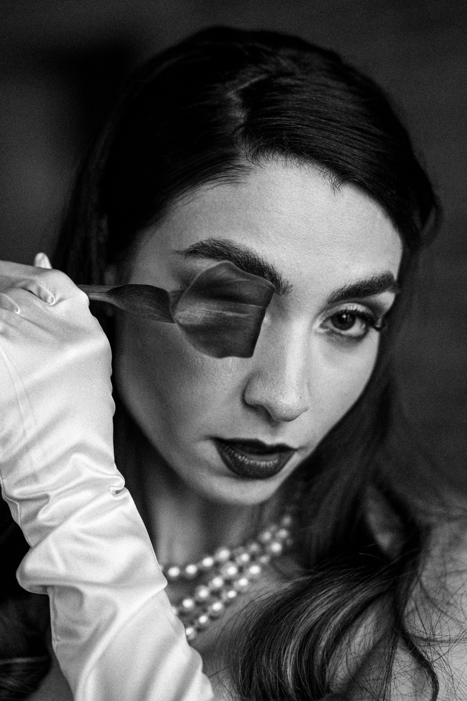 Classic black and white portrait with pearl necklace and white gloves.