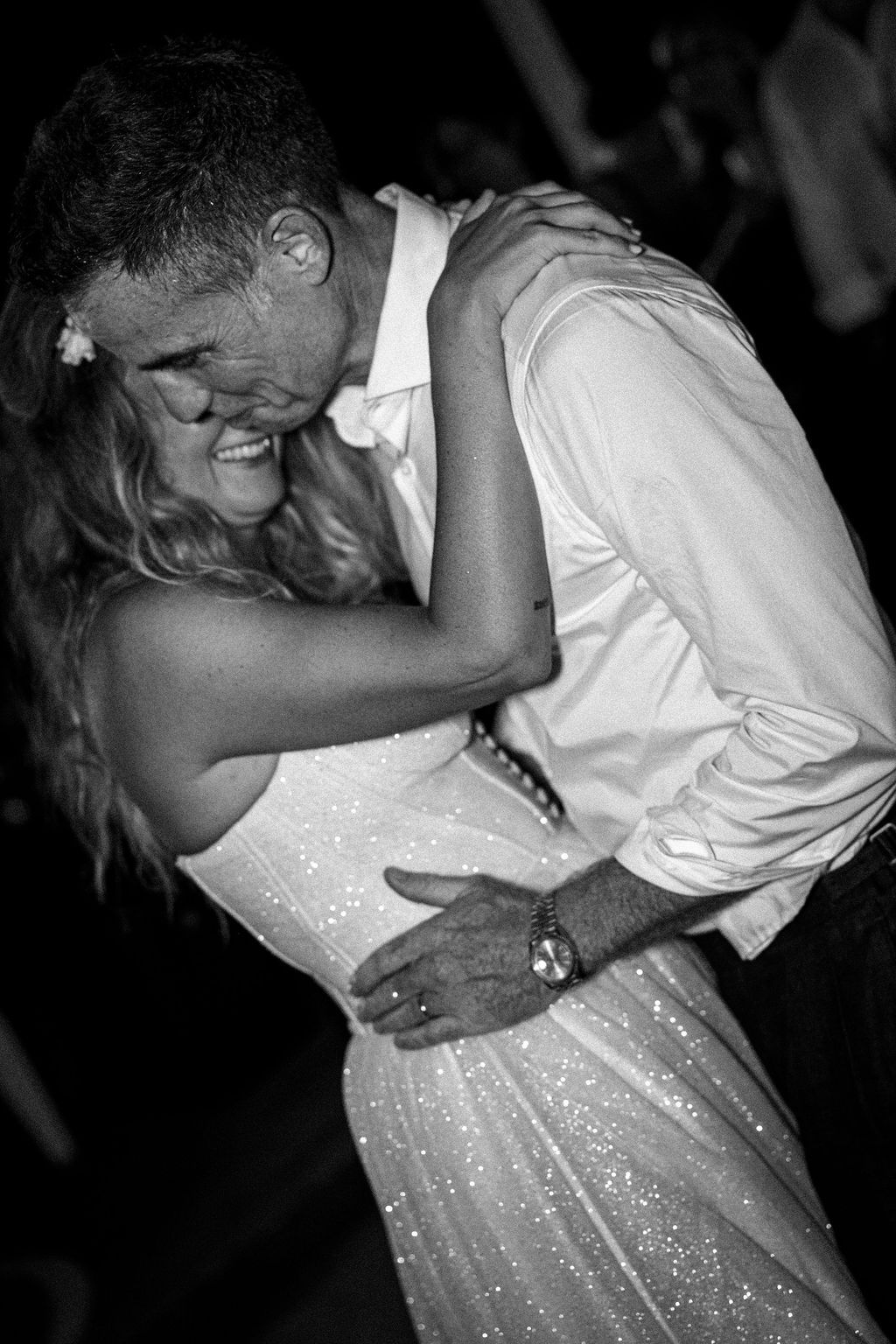 Black and white photo of couple dancing at wedding reception.