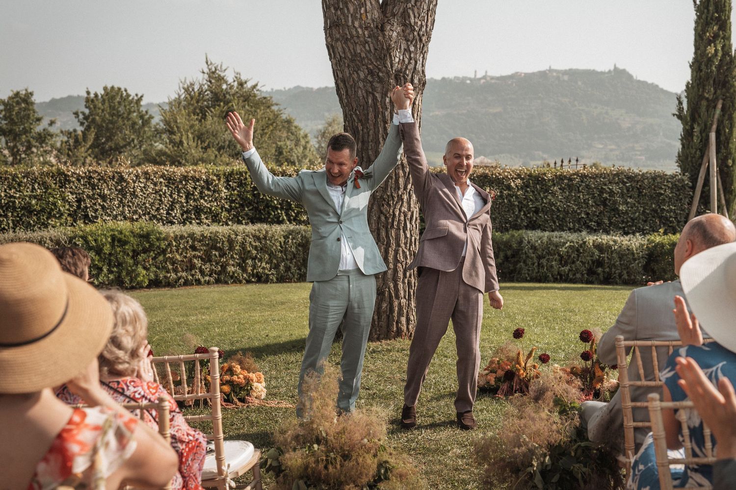 Wedding guests enjoying an outdoor reception in a garden setting with mountain views.