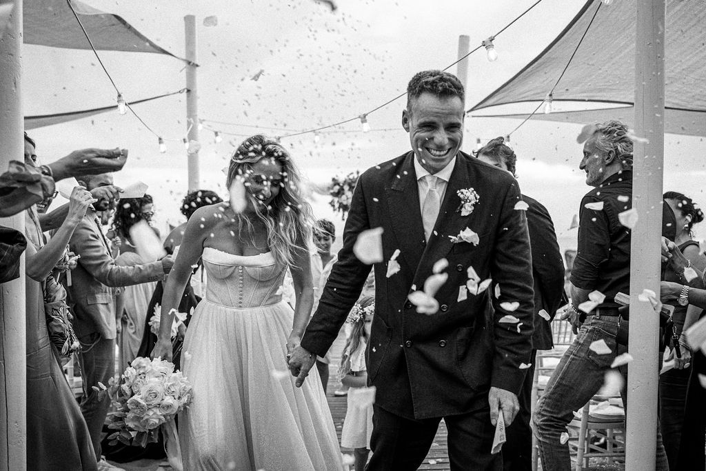 Joyful celebration moment at outdoor wedding with confetti flying through the air.
