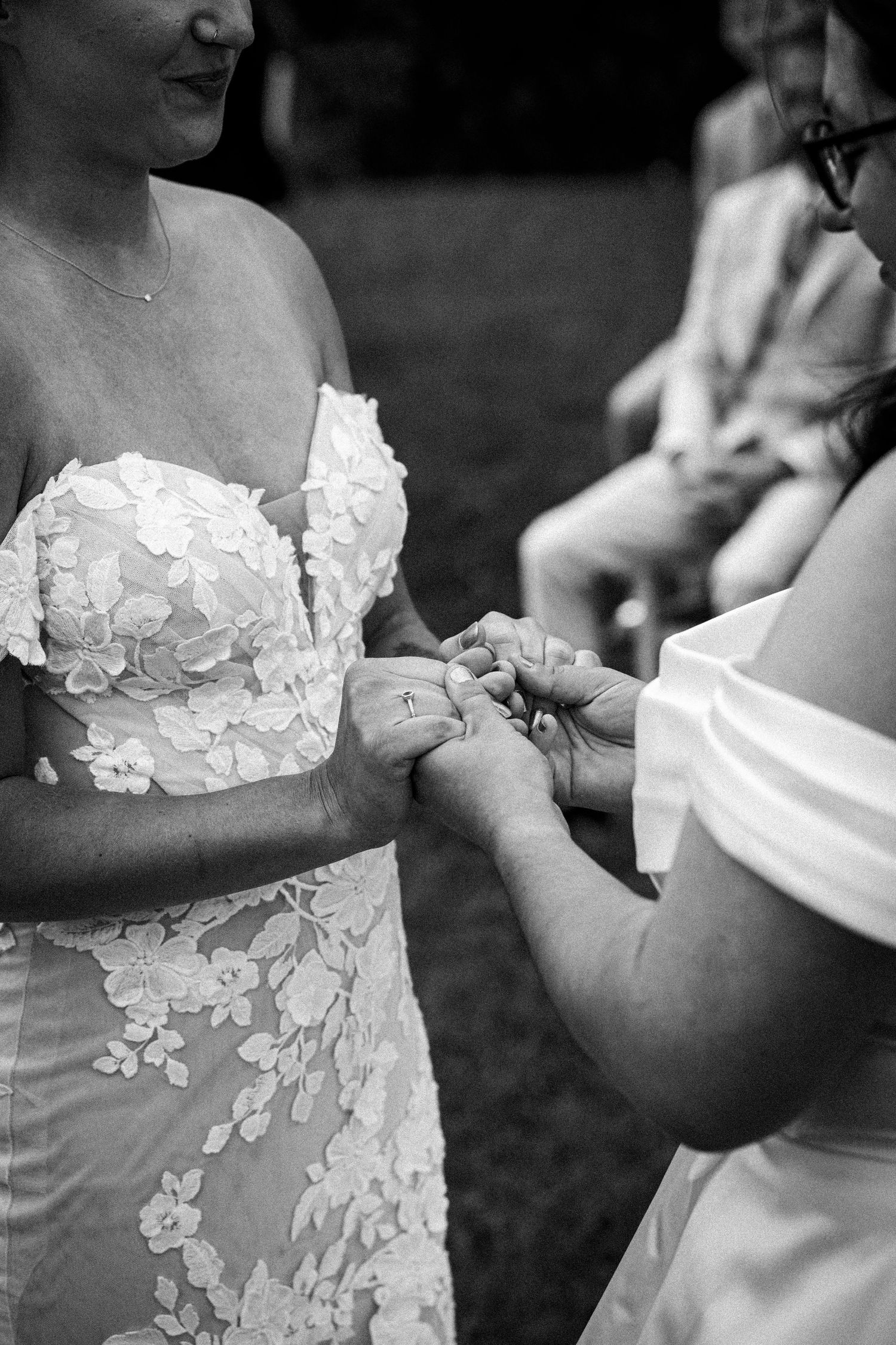 Detail shot of hands adjusting white lace wedding dress.