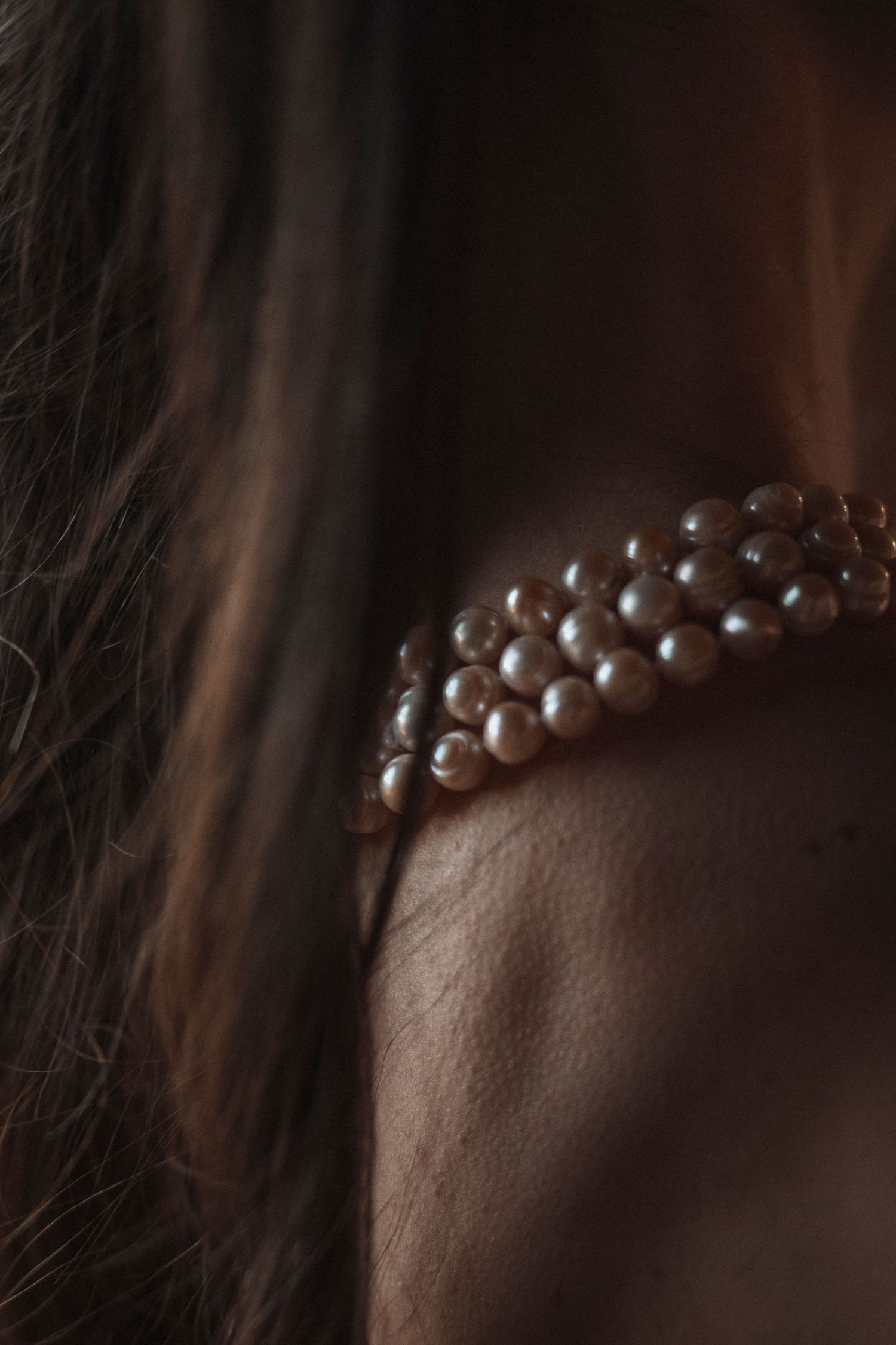 Close-up macro shot of a pearl necklace with soft lighting and shallow depth of field.