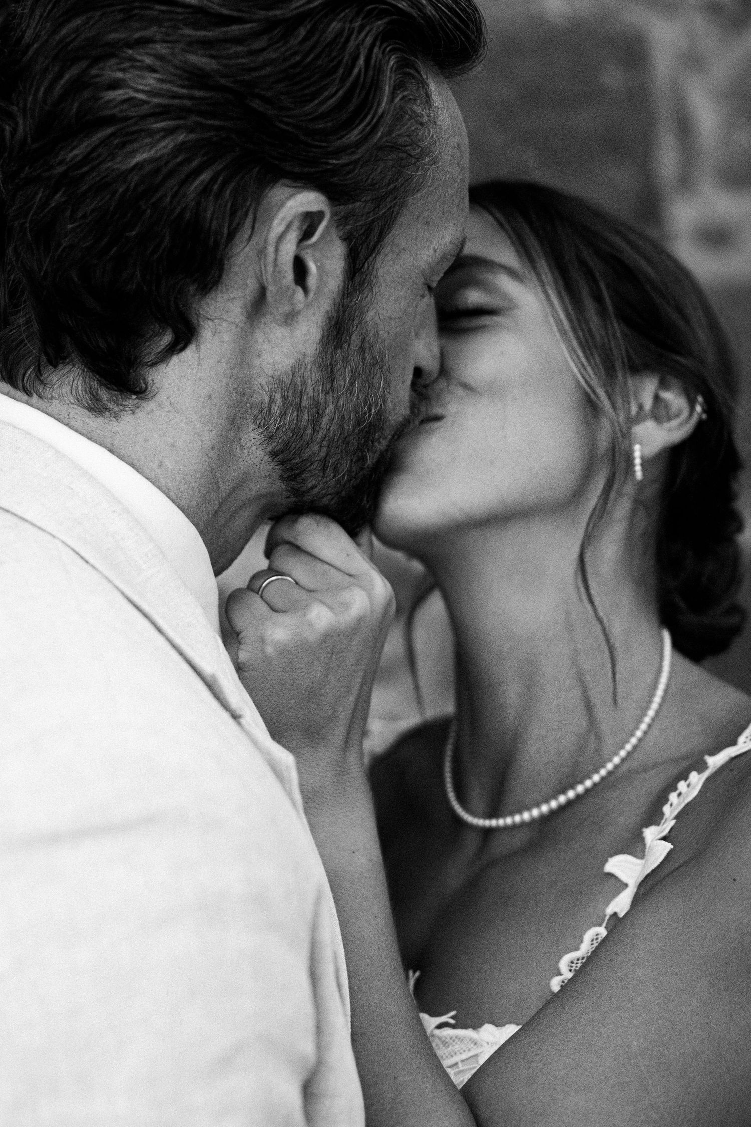 Romantic black and white close-up of a couple sharing intimate kisses.