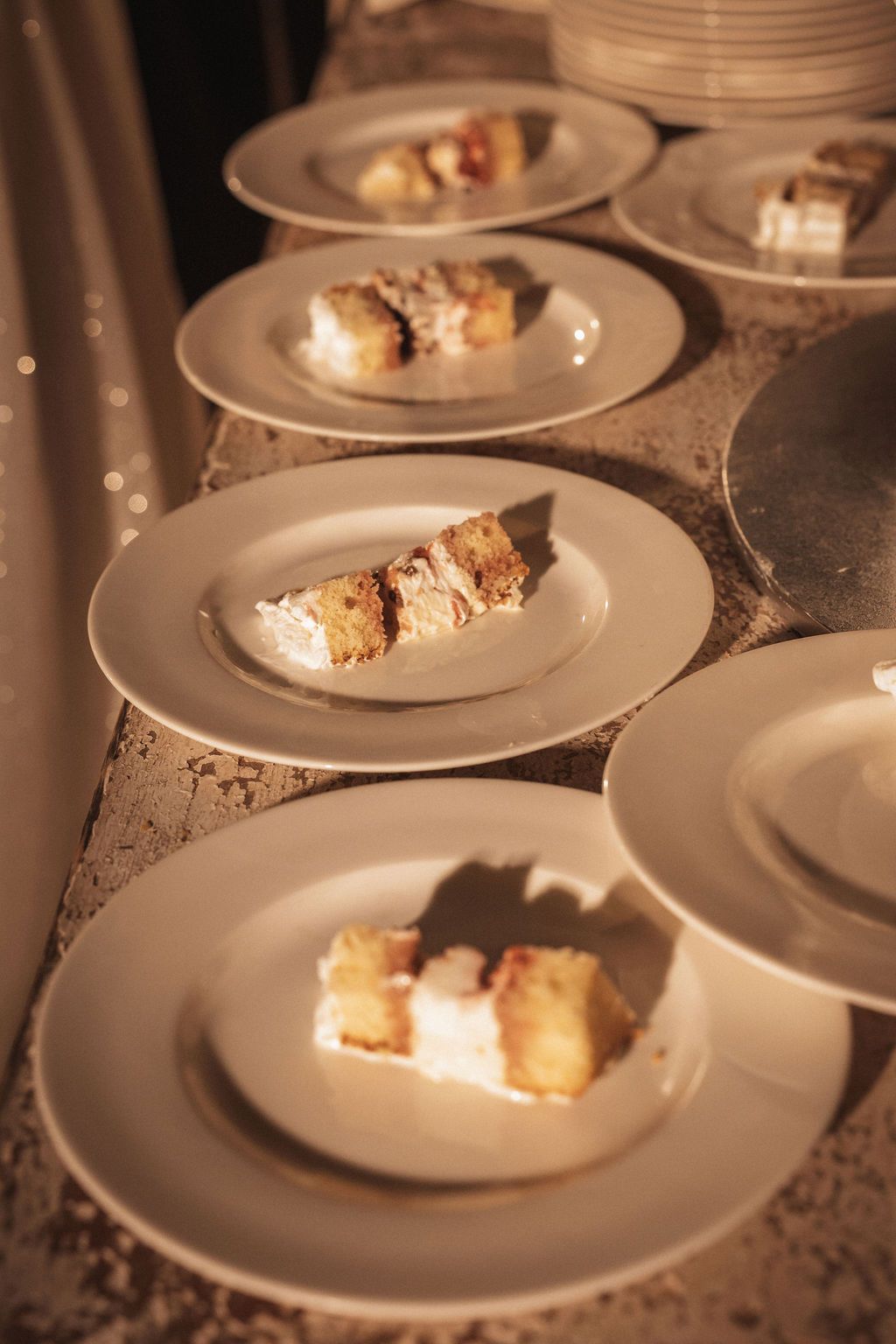 Wedding cake slices plated and ready to serve on white dishes.
