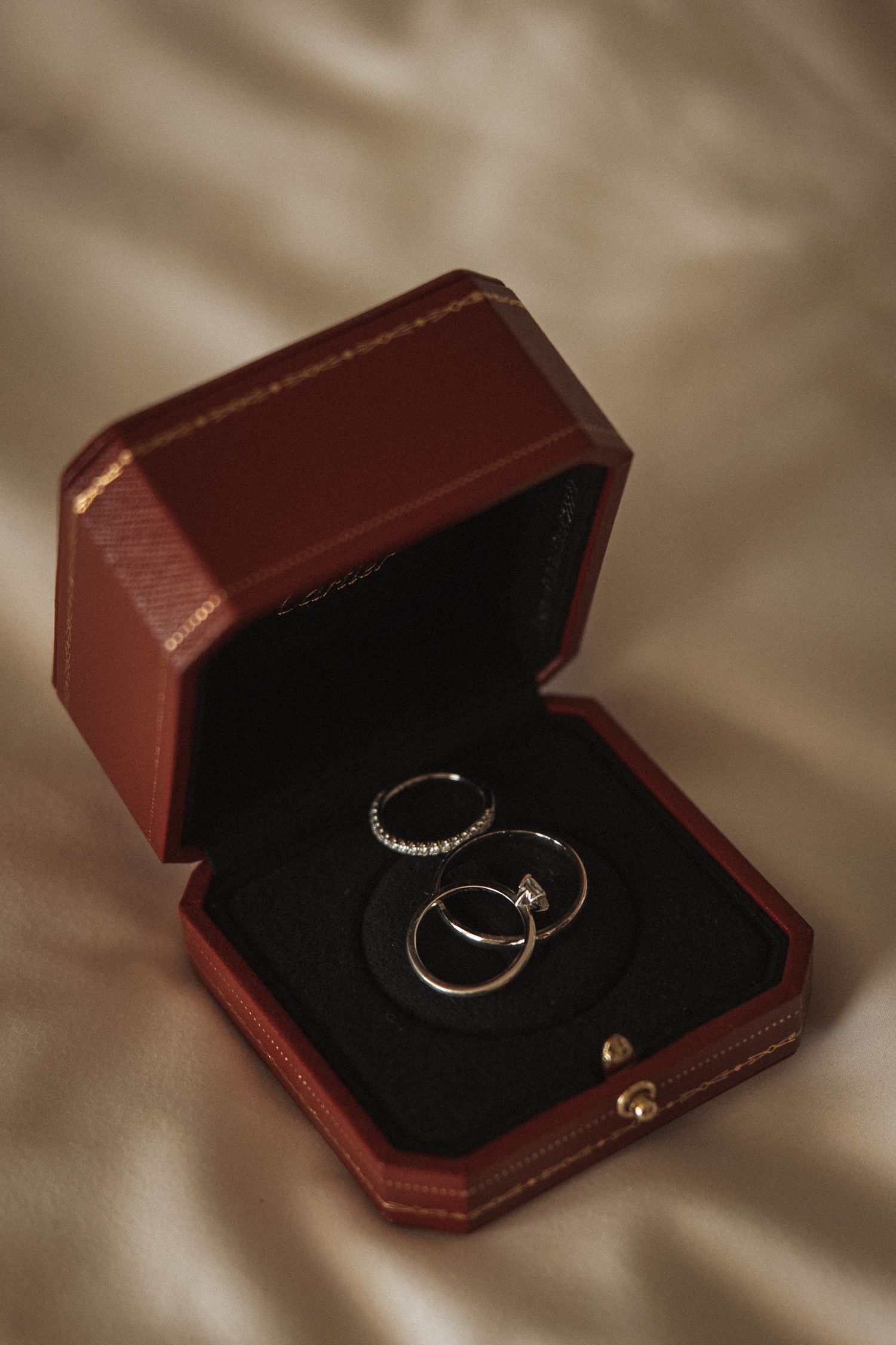 Wedding rings displayed in an open burgundy velvet jewelry box.