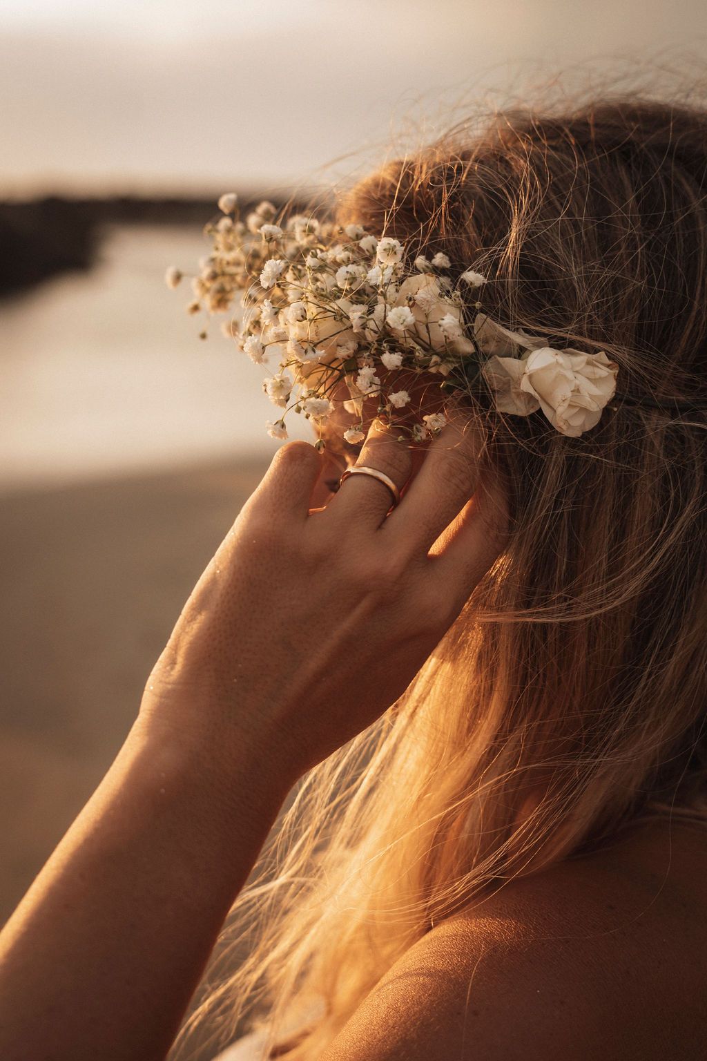 Sunlit profile of a floral crown with baby's breath flowers glowing in golden light.