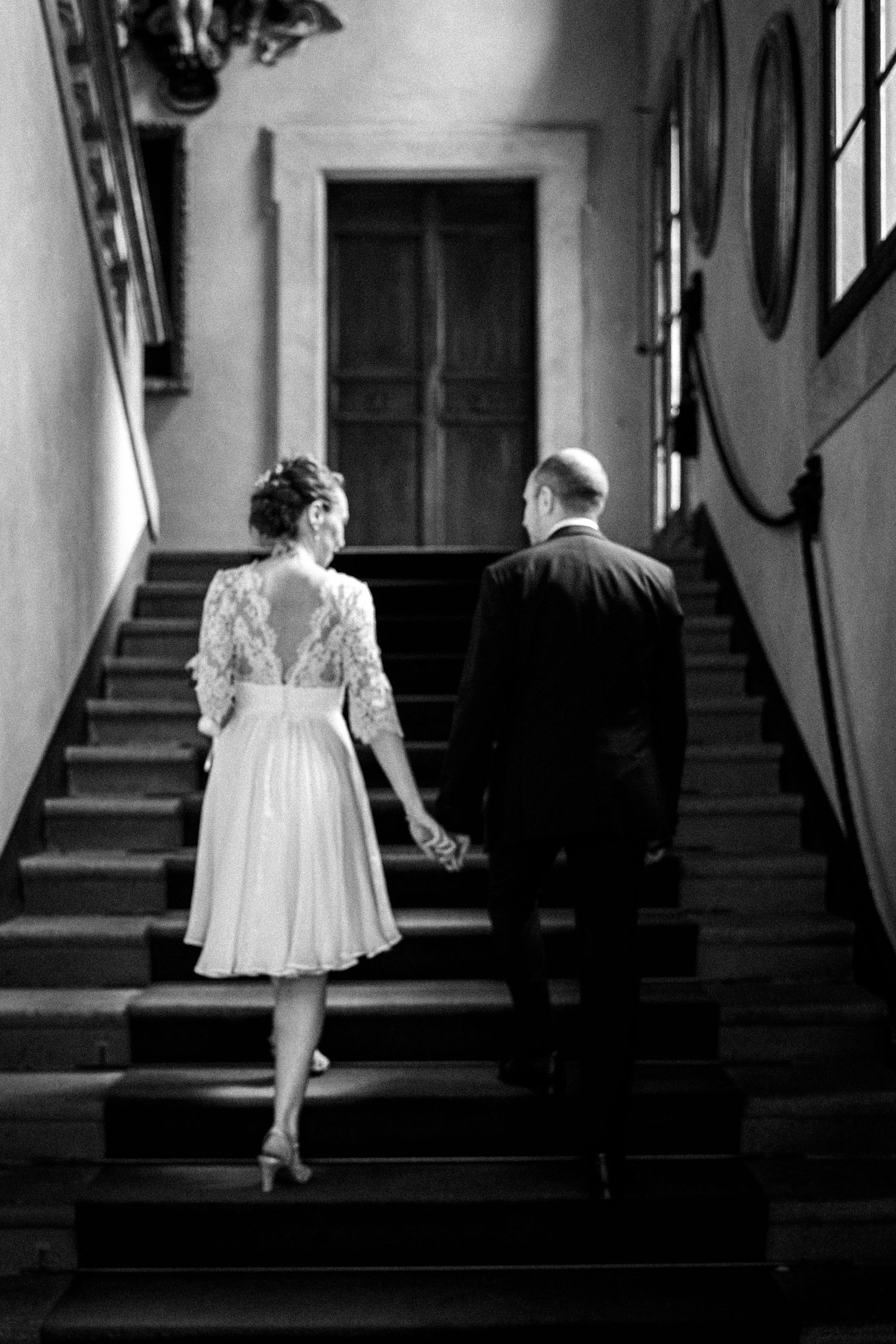 Black and white photo of a couple walking up grand staircase.