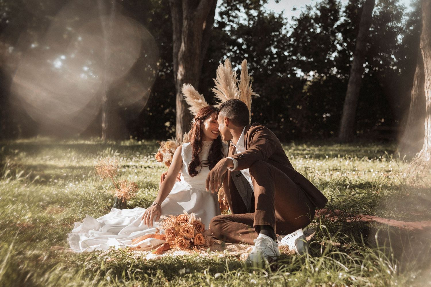 A dreamy outdoor photoshoot in a sunlit meadow with warm golden light filtering through trees.