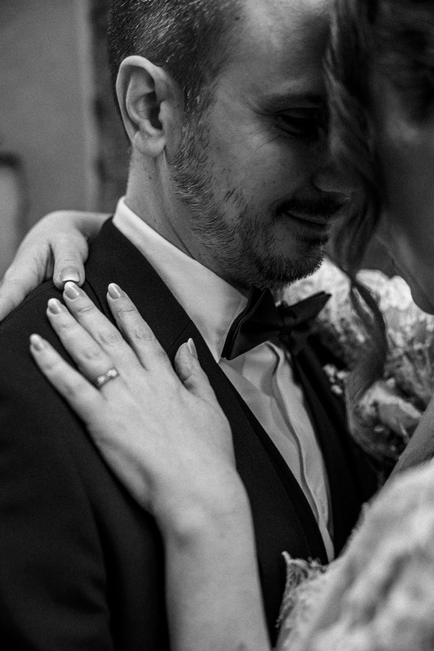 Close-up of tender moments between newlyweds in black and white.