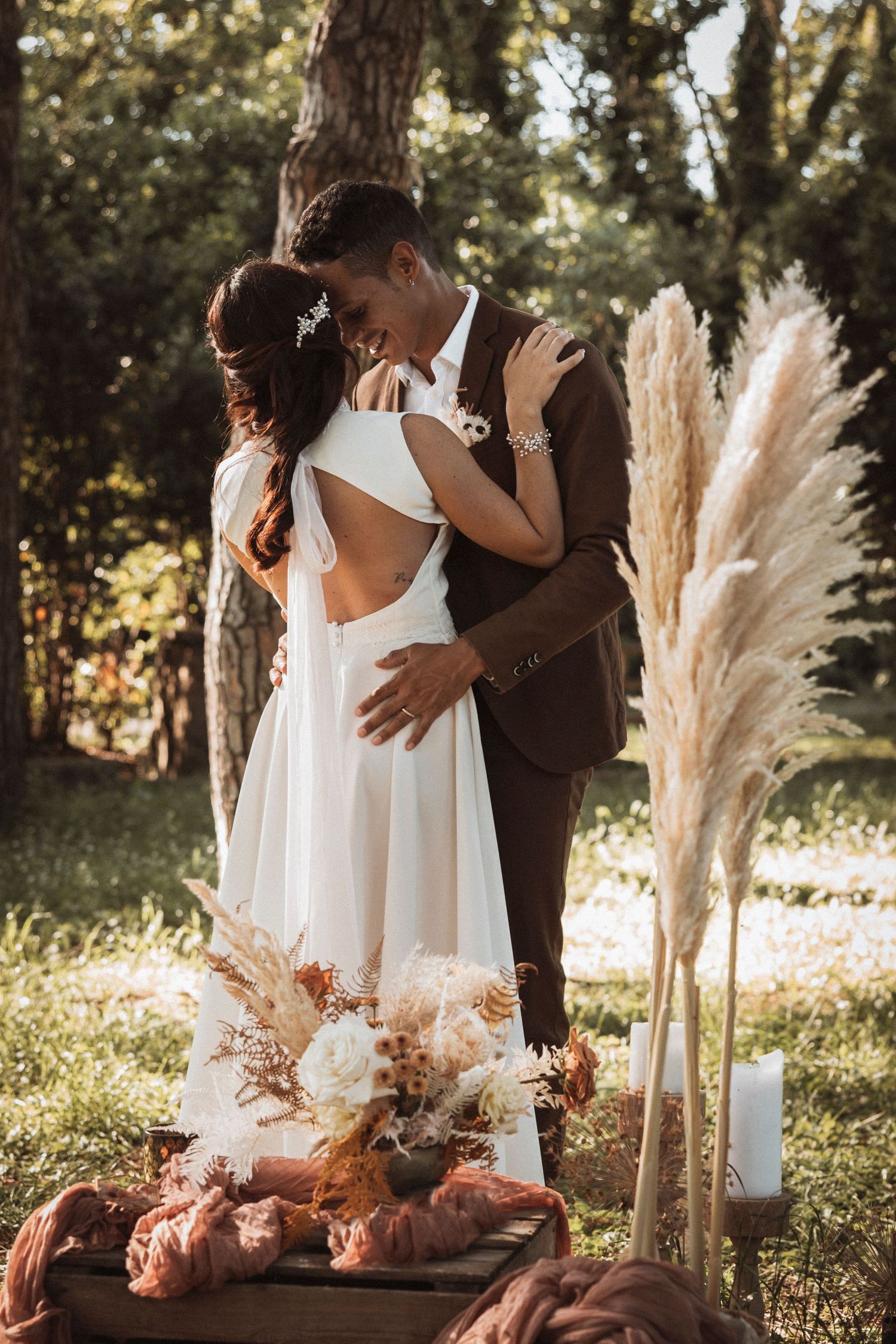 Romantic outdoor wedding scene with pampas grass decorations and soft natural lighting in a garden setting.