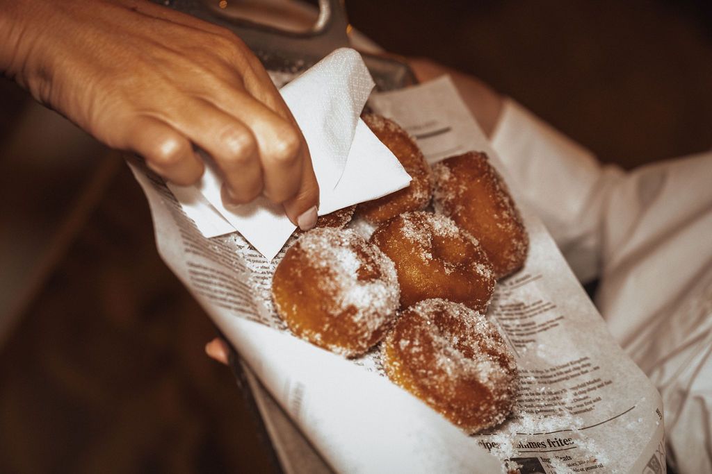 Close-up of pastries being served on paper at a celebration.