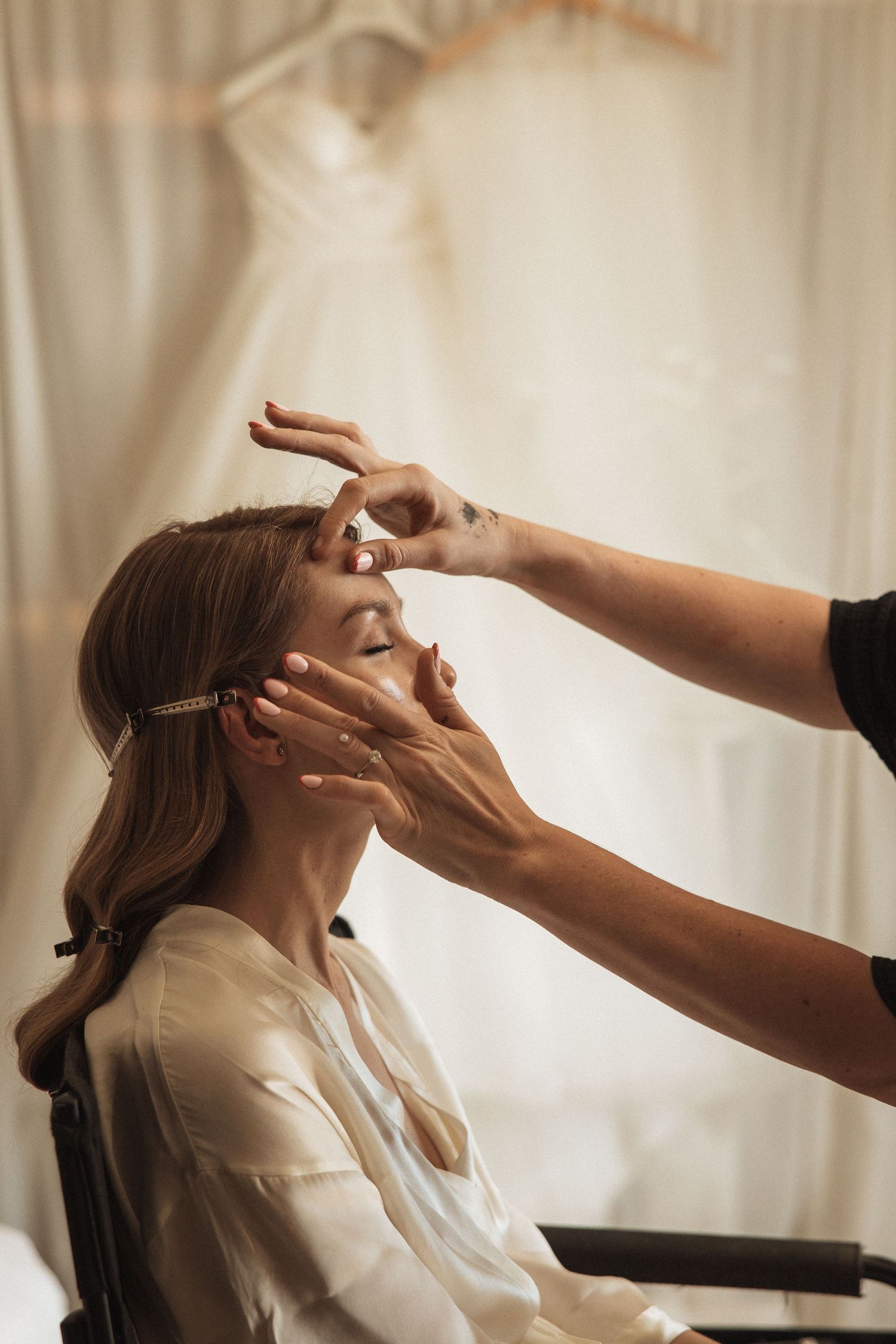 Wedding makeup artist applying cosmetics during bridal preparation.