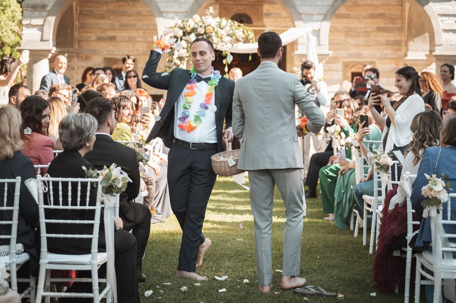 Wedding reception venue with white chairs and guests mingling outdoors.