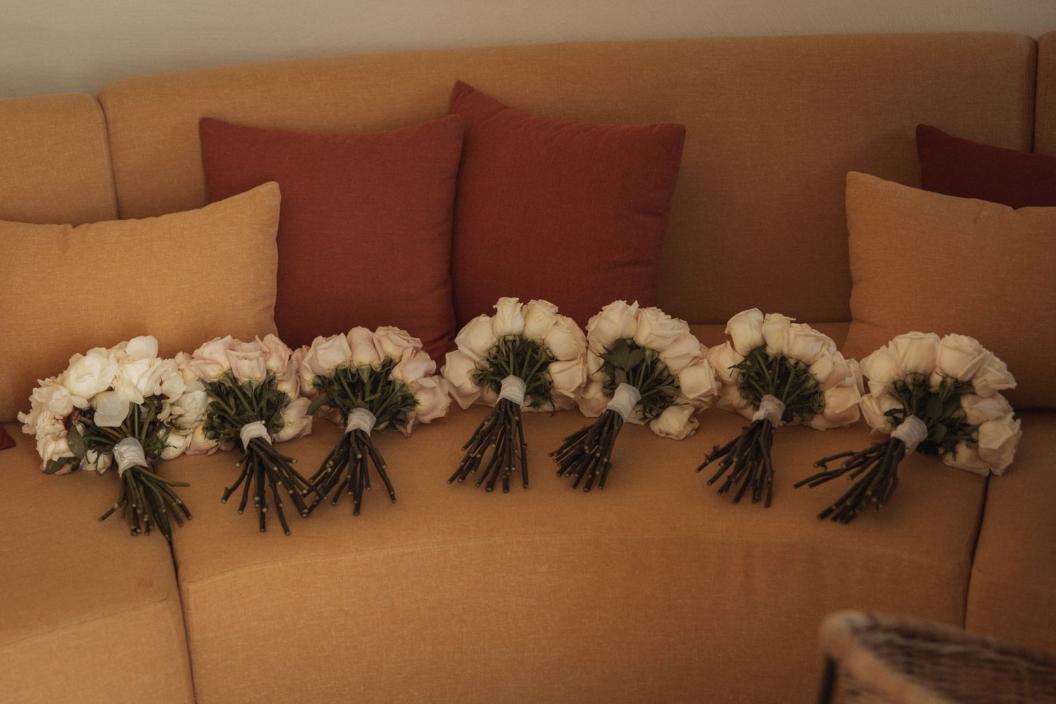 Elegant white floral arrangements with roses and greenery line a wedding venue display.