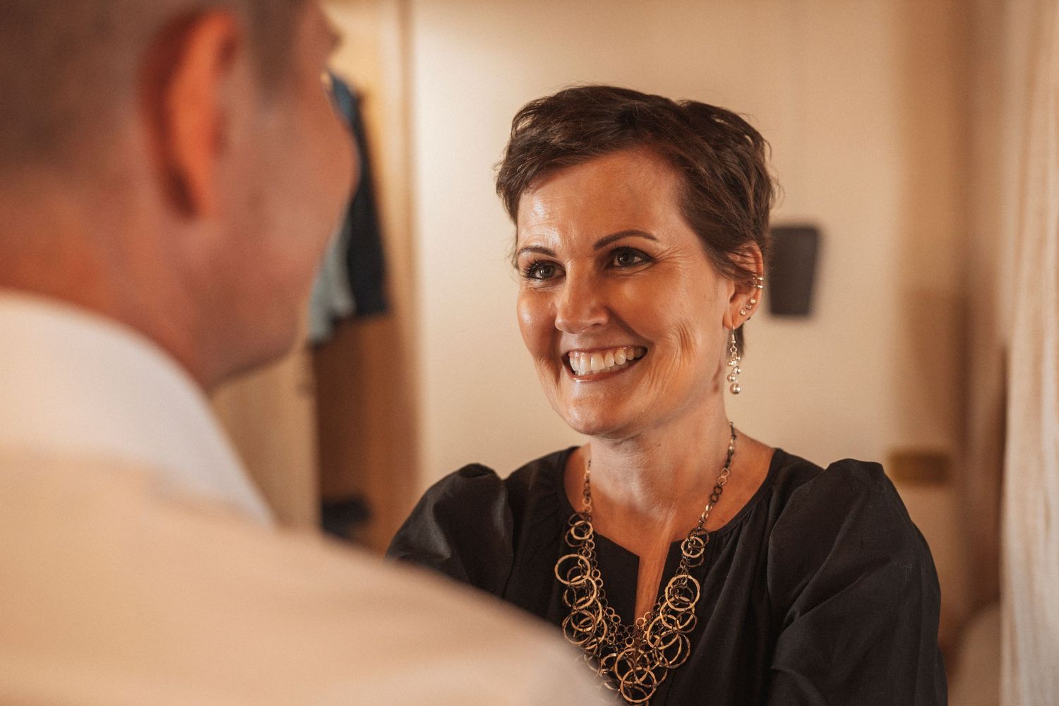 A joyful moment captured during a wedding reception with guests mingling and socializing indoors.