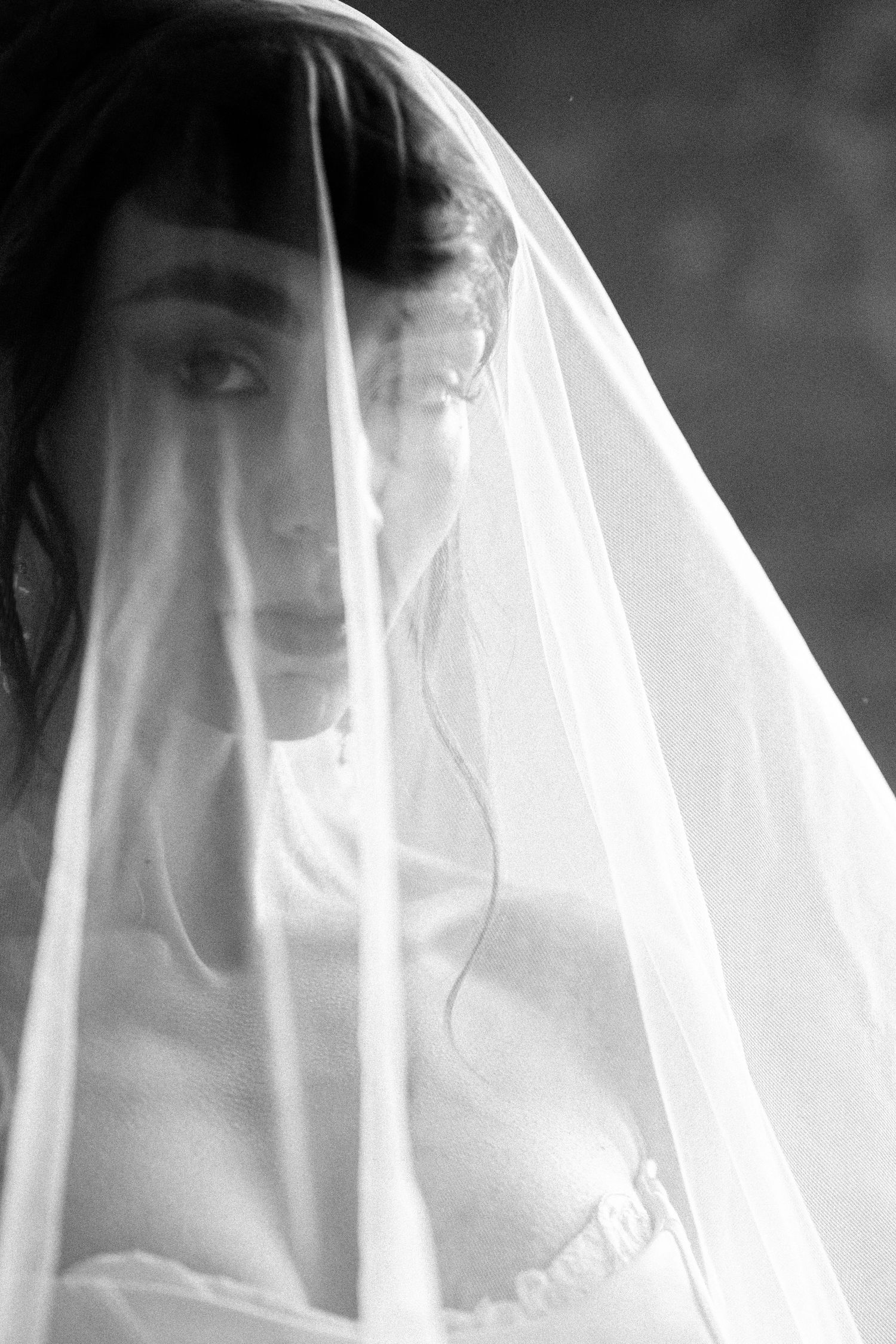 Ethereal white veil creates a dreamy silhouette in soft monochrome tones.