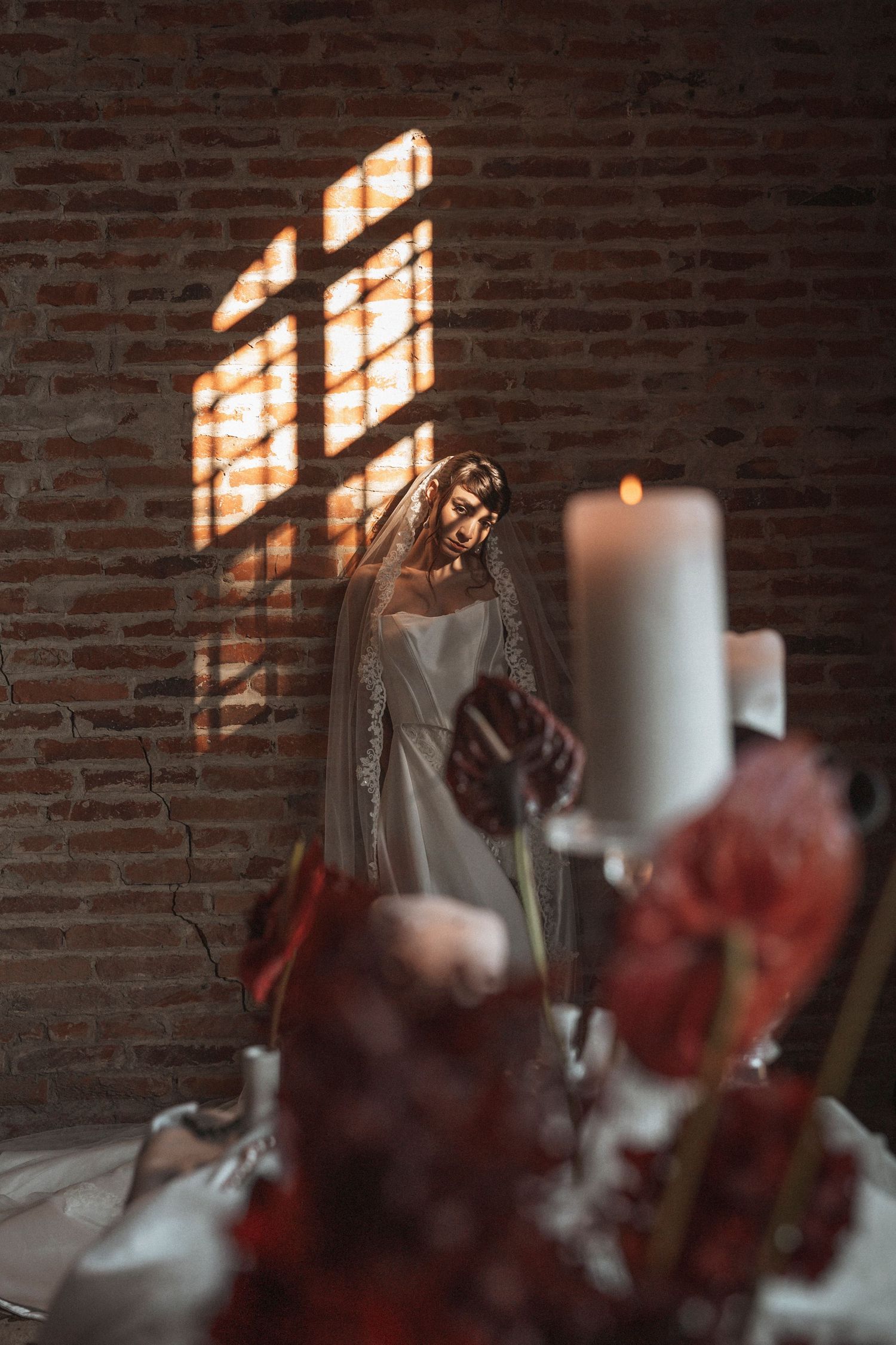 Sunlight streams through windows onto exposed brick walls creating dramatic shadows in a rustic interior space.