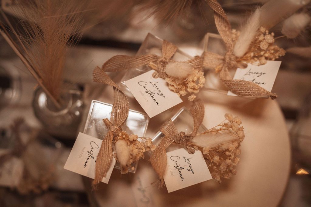 Wedding favor bags with name tags and decorative elements arranged on a table.