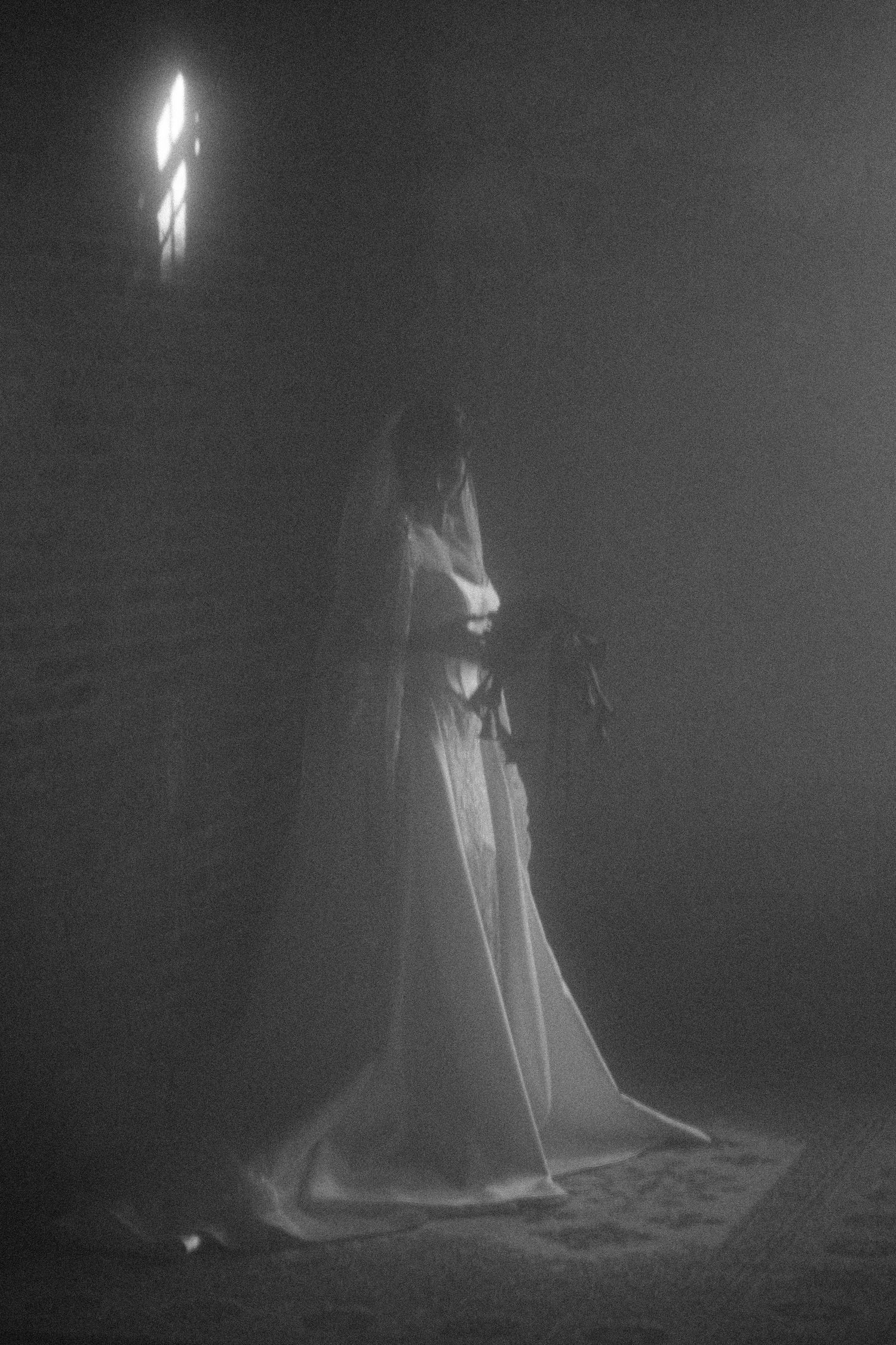 Ethereal ghostly figure illuminated in darkness creating an atmospheric and haunting scene.